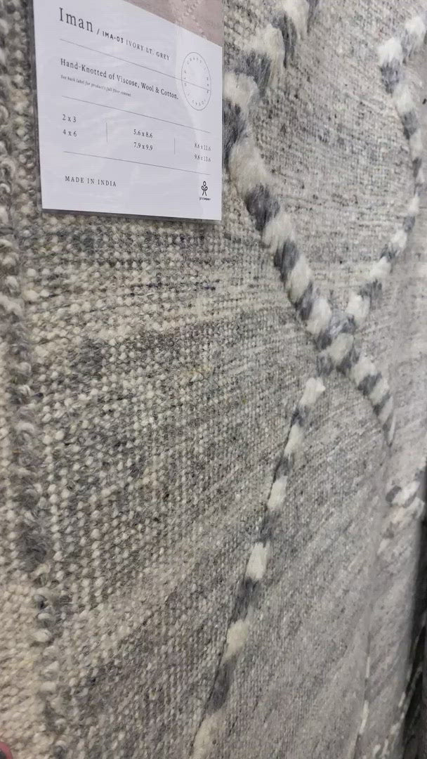 Load video: A new take on Moroccan style rugs, the Iman Collection is hand-knotted of 100% wool pile by skilled artisans in India. The surface features linear and braided details, creating tonal variations that make each piece unique. Plus, each design is finished with playful fringe.  Hand Knotted 100% Wool Pile IMA-03 Ivory / Light Grey