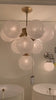 We love the white strie glass globes on this Cristol Medium Chandelier by Visual Comfort. It brings a stunning and unique look to any living room, dining room, or kitchen.   Designer: AERIN