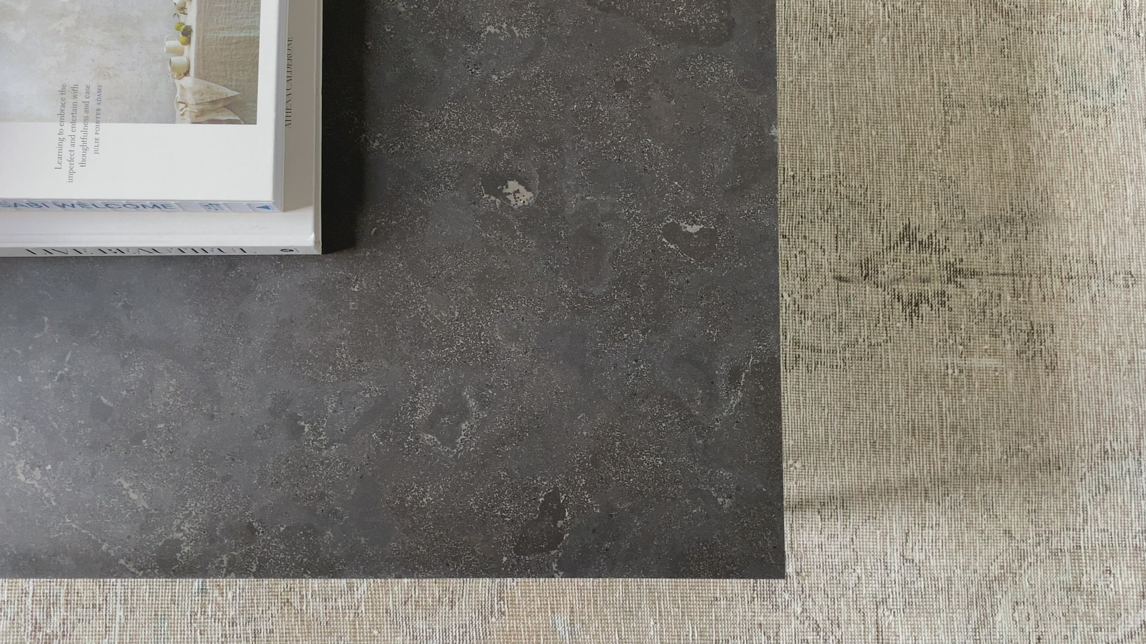 Load video: Spare beauty, casual elegance with the Harlow Bluestone Small Coffee Table. A gunmetal Parson&#39;s base with hand-rubbed, dimensional edges supports a rough-hewn bluestone slab that feels found and perfectly placed.  Size: 60&quot;w x 28&quot;d x 17&quot;h