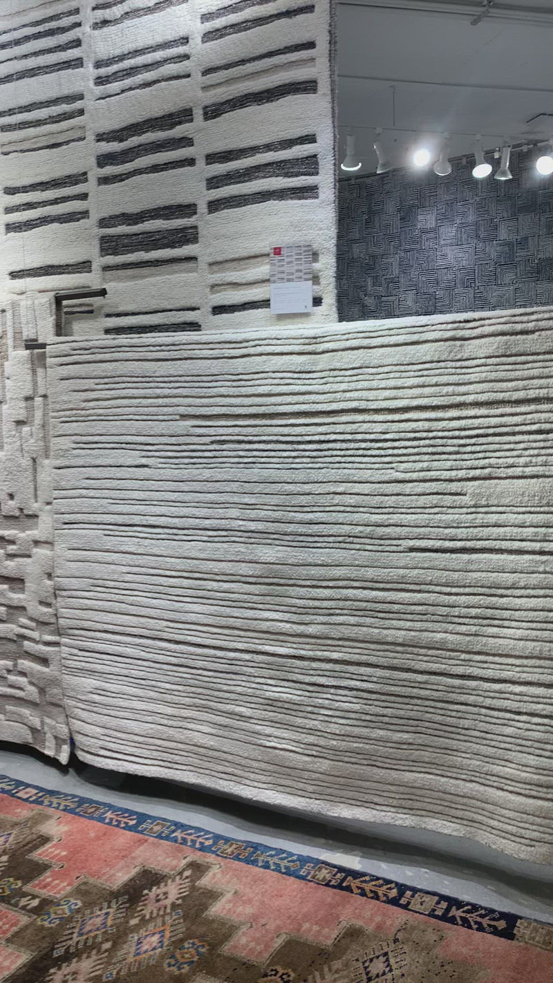 Dimensional yet soft, the Bennett Ivory / Pebble Area Rug is hand-knotted of wool, viscose and polyester in India. Featuring a new carve like high-low pile, Bennett has an ivory base with abstract tonal designs. Plus, it's plush underfoot-- a great choice for your office, bedroom, or other medium traffic areas.   Hand Knotted 45% Wool | 32% Viscose | 17% Polyester | 6% Other Fibers Pile BEN-04 Ivory/Pebble