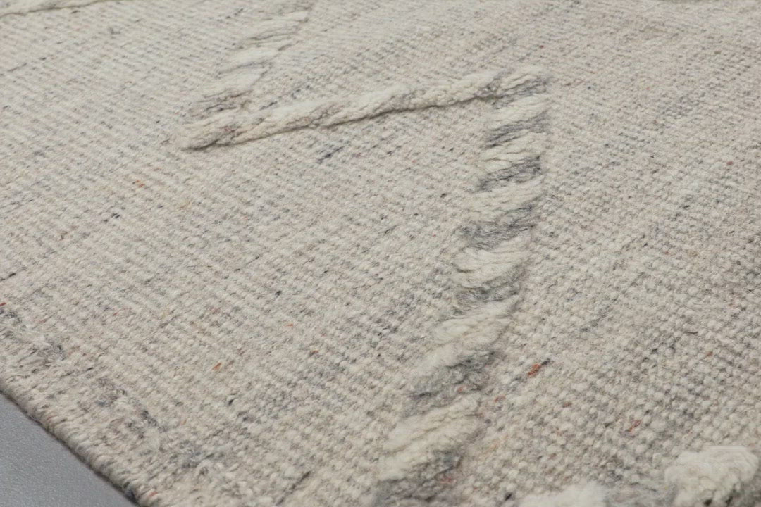 Load video: A new take on Moroccan style rugs, the Iman Collection is hand-knotted of 100% wool pile by skilled artisans in India. The surface features linear and braided details, creating tonal variations that make each piece unique. Plus, each design is finished with playful fringe.  Hand Knotted 100% Wool Pile IMA-03 Ivory / Light Grey