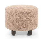 Place this round ottoman just about anywhere. Upholstered in a faux Mongolian shearling with a high pile fur in a toasty tan neutral hue. Burnt birch parawood legs add a touch of contrast.Collection: Kensingto Amethyst Home provides interior design, new home construction design consulting, vintage area rugs, and lighting in the Boston metro area.