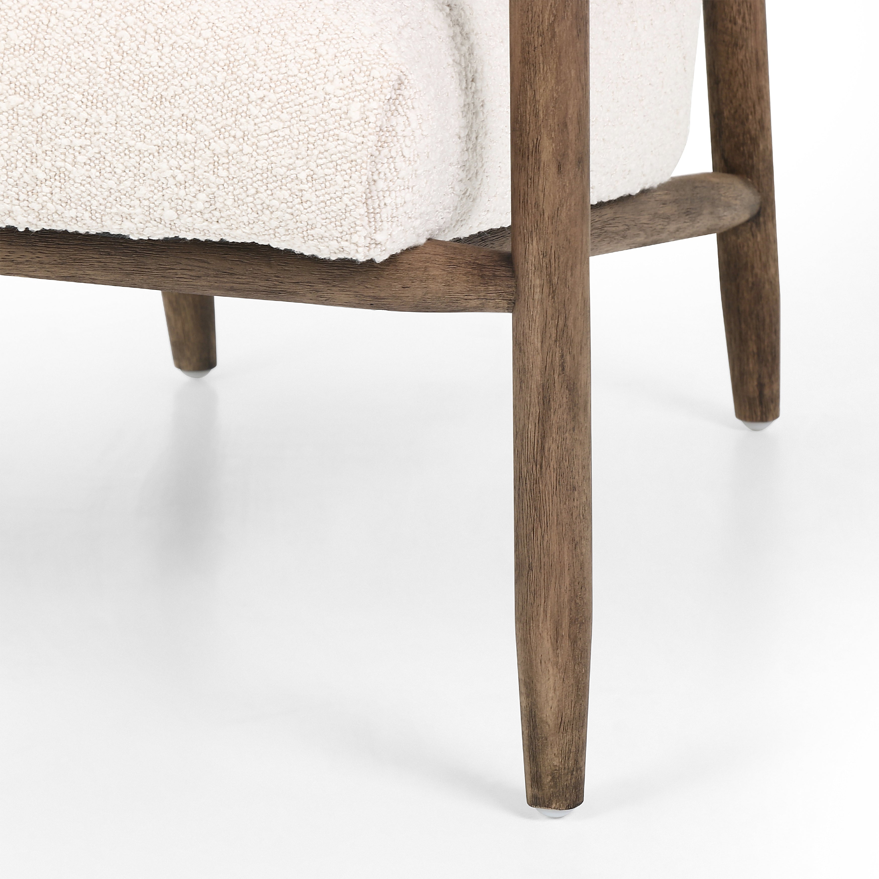 Featuring Arnett Chair by Four Hands at Amethyst Home. Textural cream boucle seating offers a sumptuous sit, with complementary wire-brushed parawood framing forming a slim U shape. Two posterior top-grain leather straps add a stylish finishing touch. Performance fabrics are specially created to withstand spills, stains, high traffic and wear, ensuring long-term comfort and unmat. Amethyst Home provides interior design, new construction, custom furniture and area rugs in the Kansas City metro area