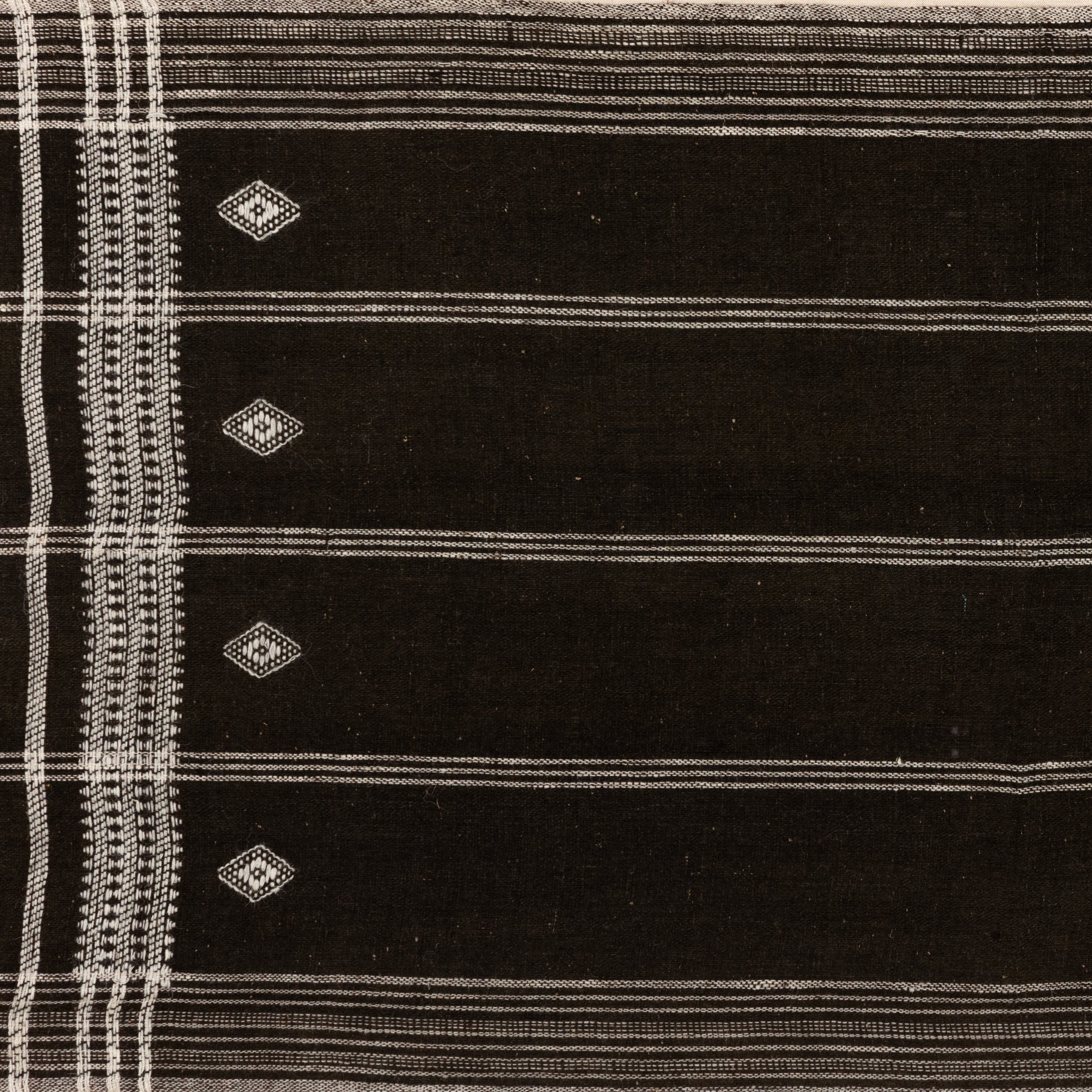 Featuring Bhujodi Chocolate Textile by Four Hands at Amethyst Home. A Bhujodi-style textile is framed within rustic walnut for a gallery-quality look. Handmade in Austin, Texas.Overall Dimensions: 75"W x 2.50"L x 35"HColors: Black 2.5 Maple, Bhujodi ChocolateMaterials: American Maple, 100% Wool. Amethyst Home provides interior design, new home construction design consulting, vintage area rugs, and lighting in the Salt Lake City metro area.