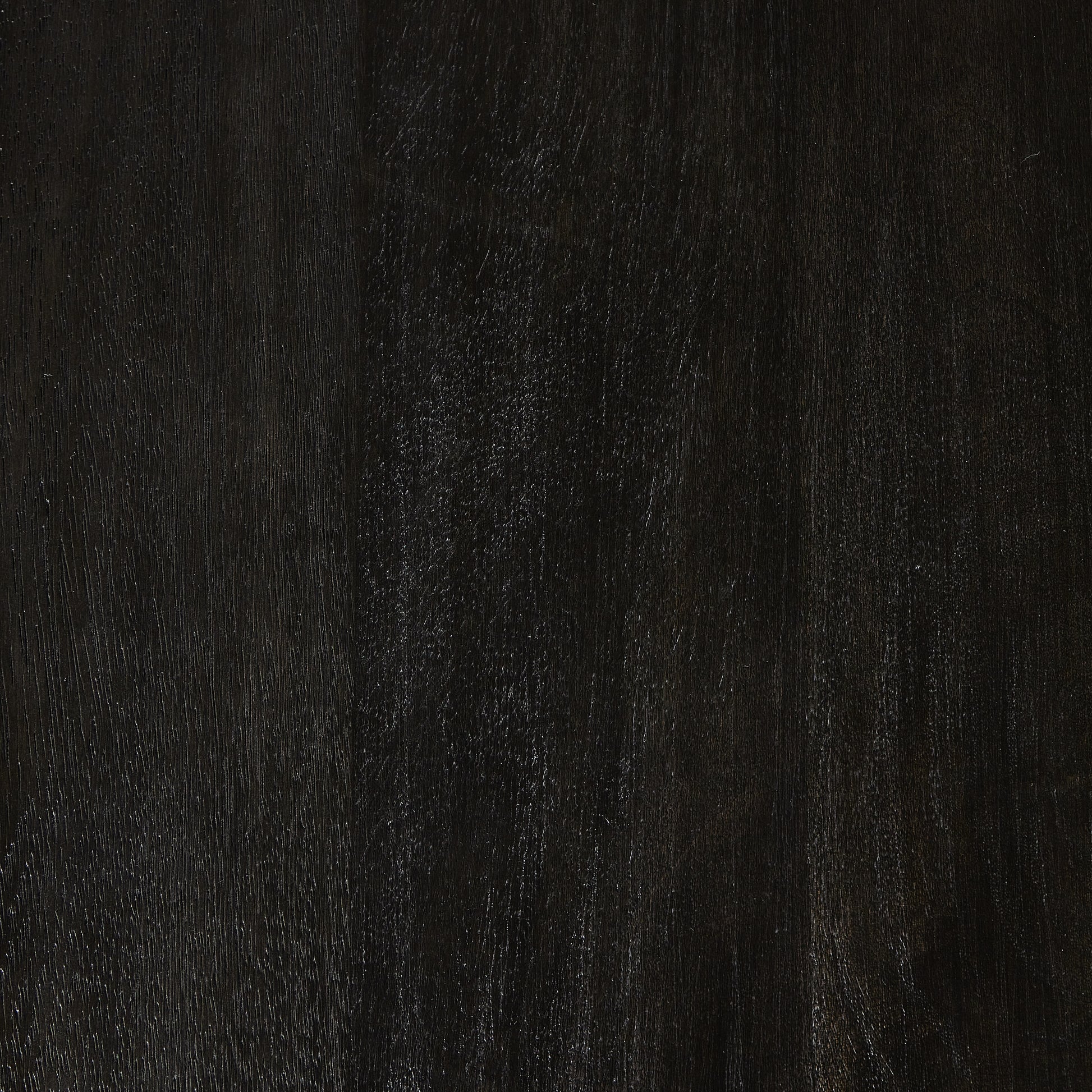 A rounded table of solid mango wood forms purposefully burnished edges, producing a warm black patina for the home dining table. Amethyst Home provides interior design, new construction, custom furniture, and area rugs in the San Diego metro area.