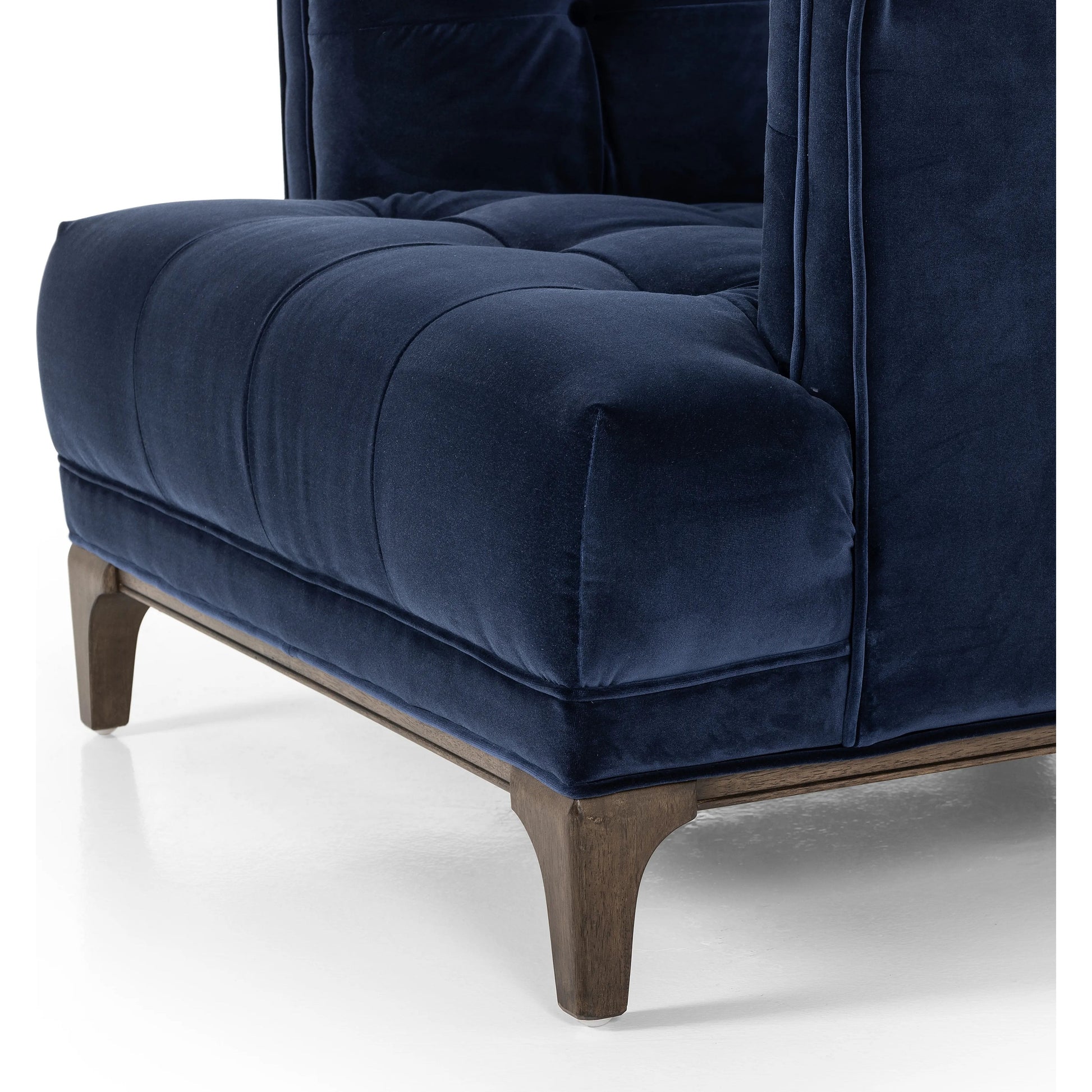 This low, tailored midcentury silhouette is upholstered in a velvety navy fabric, with dramatic blind tufting for texture.Collection: Kensingto Amethyst Home provides interior design, new home construction design consulting, vintage area rugs, and lighting in the Dallas metro area.
