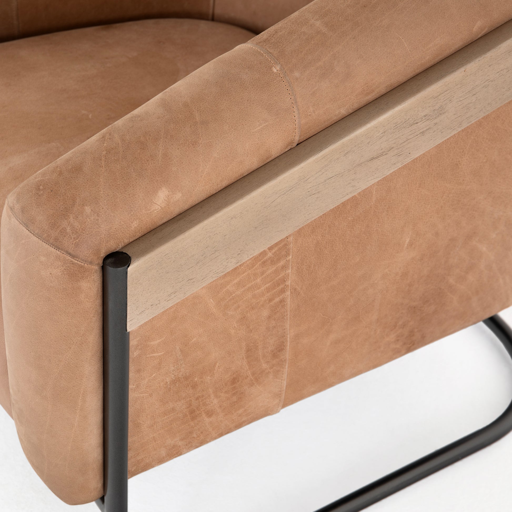 Deco-driven elegance. A fresh take on the traditional cigar chair, impeccably tailored tan top-grain leather forms a curvy U shape, with solid parawood detailing adding interest to gunmetal-finished iron framing. Amethyst Home provides interior design, new construction, custom furniture, and area rugs in the Des Moines metro area.