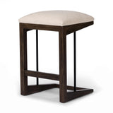 Featuring Finn Sienna Brown Oak Counter Stool by Four Hands at Amethyst Home. A stunner from every angle, this architecturally inspired stool features an angular base crafted from solid oak with two iron rods for added support and visual interest. Seat is upholstered in a linen/cotton/poly blend performance fabric with subtle texture throughout. Performance. Amethyst Home provides interior design, new home construction design consulting, vintage area rugs, and lighting in the Calabasas metro area.