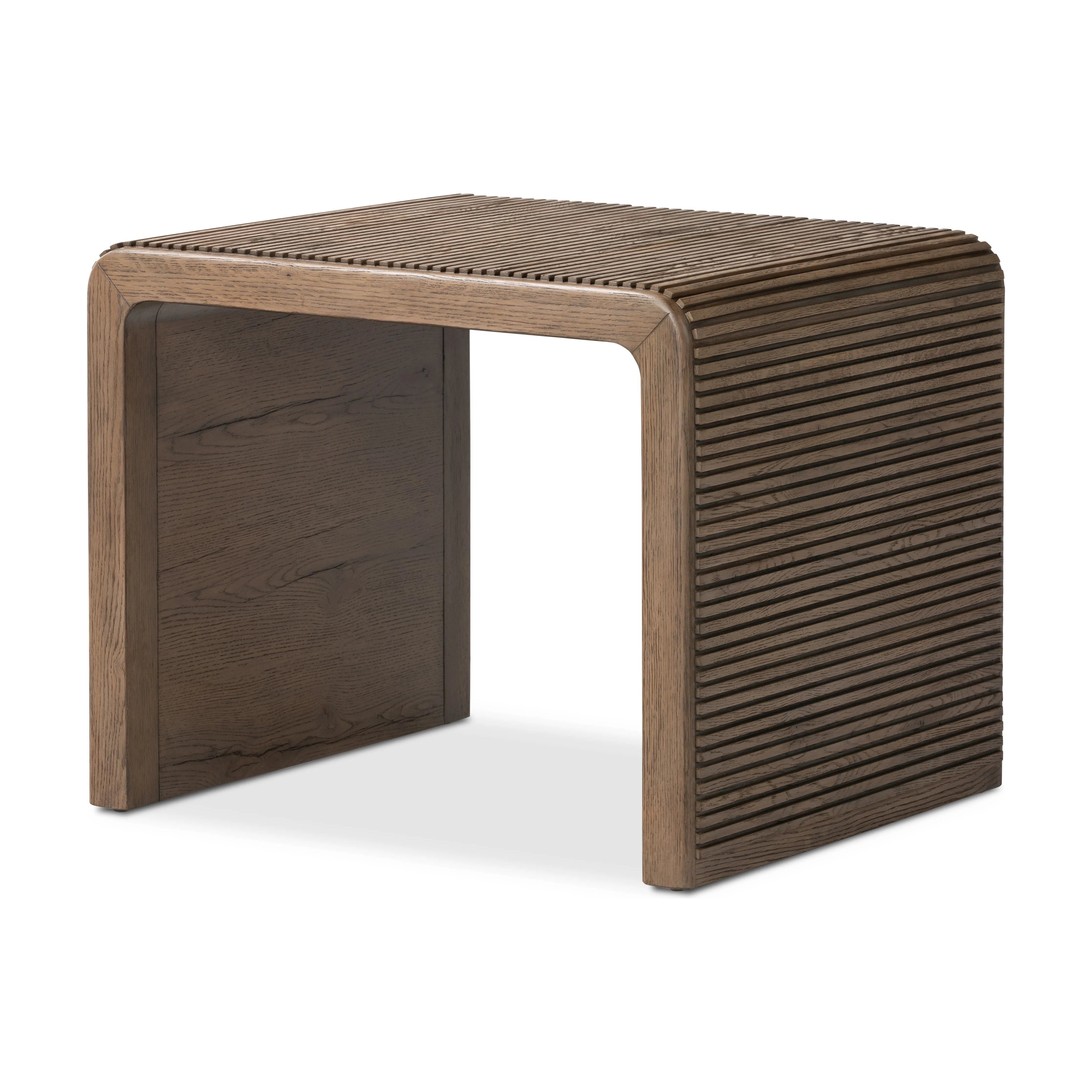 Made from rustic-finished oak, linear reeding and a curved shape define this midcentury-spirited end table. Designed in partnership with longtime Four Hands collaborator Thomas Bina and Brazilian designer Ronald Sasson.Collection: Bin Amethyst Home provides interior design, new home construction design consulting, vintage area rugs, and lighting in the Austin metro area.