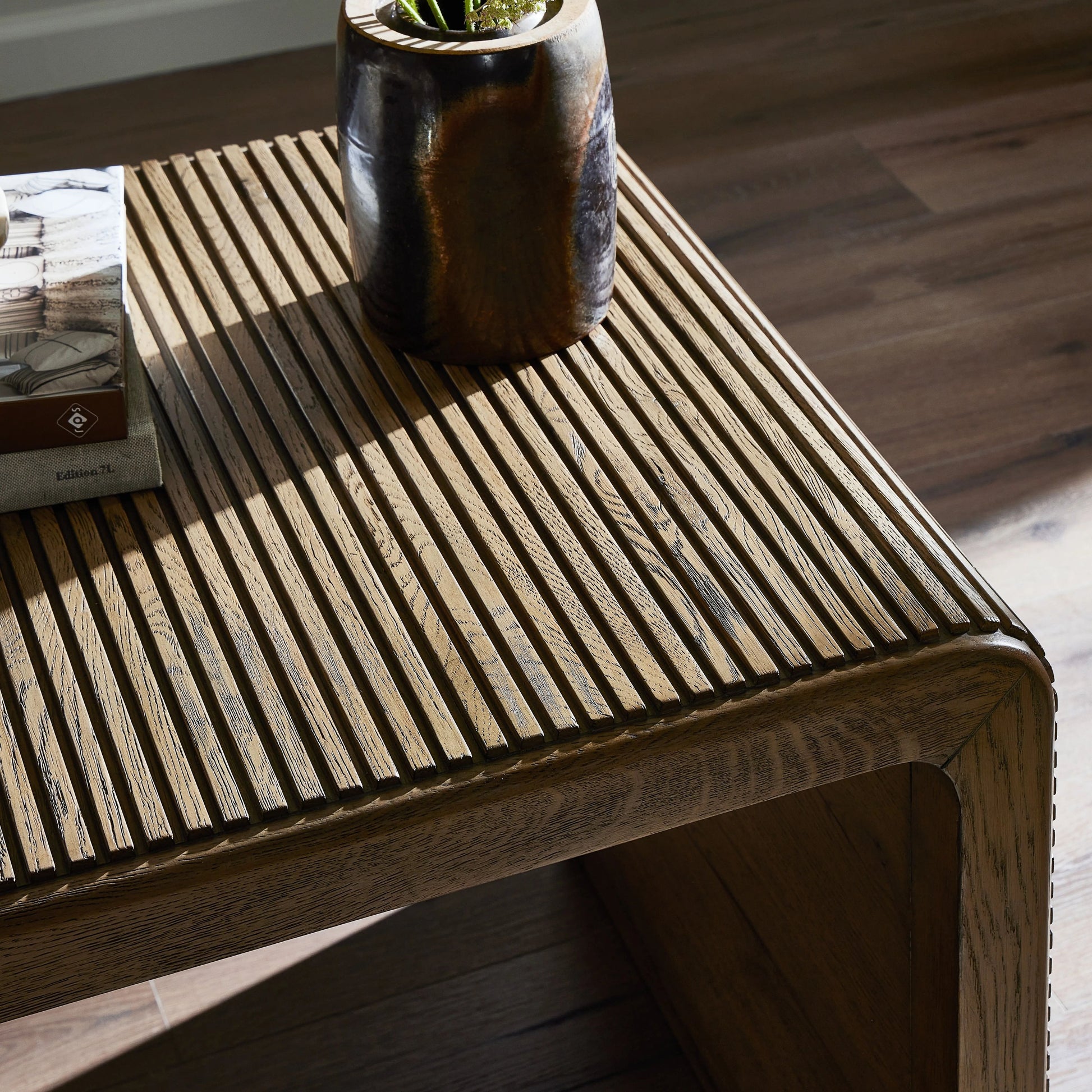 Made from rustic-finished oak, linear reeding and a curved shape define this midcentury-spirited end table. Designed in partnership with longtime Four Hands collaborator Thomas Bina and Brazilian designer Ronald Sasson.Collection: Bin Amethyst Home provides interior design, new home construction design consulting, vintage area rugs, and lighting in the Tampa metro area.