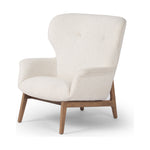 The classic wingback chair is updated with a midcentury-style base. Flared arms and a high winged back with blind tufting offer all-around comfort. Upholstered in a heavily textured boucle performance fabric bringing movement and everyday function to the piece. Amethyst Home provides interior design, new construction, custom furniture, and area rugs in the Alpharetta metro area.