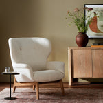 The classic wingback chair is updated with a midcentury-style base. Flared arms and a high winged back with blind tufting offer all-around comfort. Upholstered in a heavily textured boucle performance fabric bringing movement and everyday function to the piece. Amethyst Home provides interior design, new construction, custom furniture, and area rugs in the Monterey metro area.