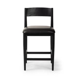 Monochromatic meets midcentury with this counter-height stool. Structured while comfortable, the tapered-leg chair pairs an ebony wood frame with a faux leather cushion.Collection: Ashfor Amethyst Home provides interior design, new home construction design consulting, vintage area rugs, and lighting in the Omaha metro area.