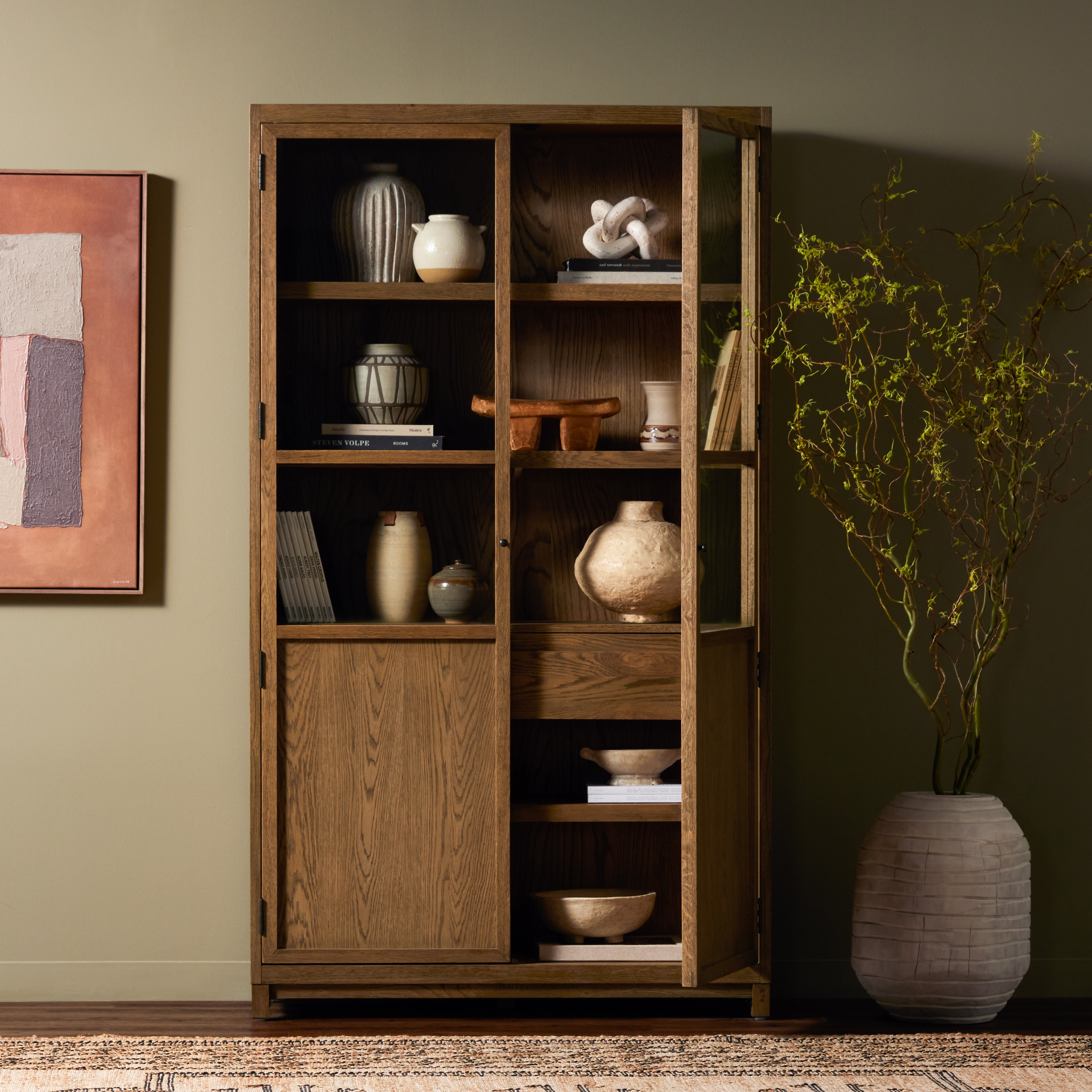 Drifted oak frames the interior shelving of this cabinet. Glass doors allow for prized possessions to dazzle on full display while spacious cabinets add out-of-view storage. Amethyst Home provides interior design, new construction, custom furniture, and area rugs in the Kansas City metro area.