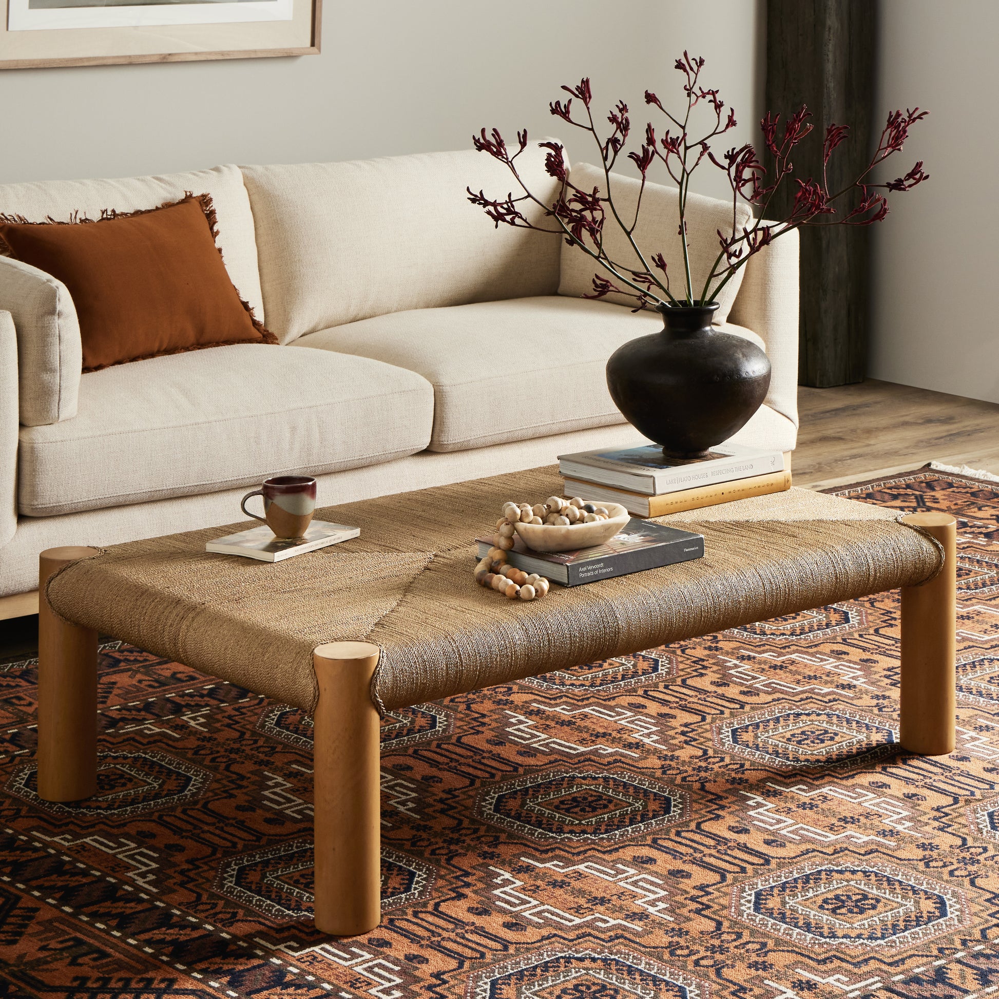The traditional coffee table gets a textural twist. Chunky column legs of light-washed mahogany support a rectangular tabletop of braided sugar palm leaves. Amethyst Home provides interior design, new construction, custom furniture, and area rugs in the Scottsdale metro area.