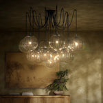Featuring Spider Black Gunmetal Clear Ribbon Glass Cord Chandelier by Four Hands at Amethyst Home. Clear glass spheres float at varying lengths for a statement-making piece. Each globe is individually blown, shaped and sculpted by hand through a one-hour process. The finish on the brass frame is achieved through a specialized process that turns the brass in. Amethyst Home provides interior design, new home construction design consulting, vintage area rugs, and lighting in the Nashville metro area.