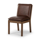 Inspired by the folded pillow form, the seat and back cushions of this oak dining chair are covered in brown top-grain leather. The chair back features leather strap details for a mixed material touch.Collection: Ashfor Amethyst Home provides interior design, new home construction design consulting, vintage area rugs, and lighting in the San Diego metro area.