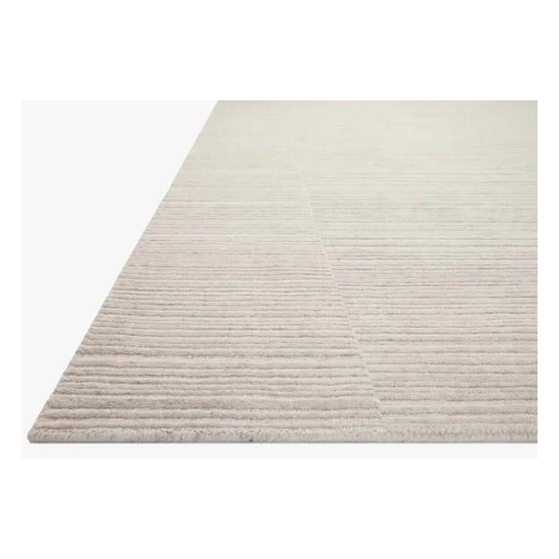 Sleek and modern, the Lou Collection is a luxurious hand-loomed area rug by Amber Lewis x Loloi. While the rug presents a minimal aesthetic, up close, it has a broken stripe pattern that creates a slightly ribbed effect. It’s made with a blend of wool and viscose that’s soft and durable, an elevated neutral for any room. Amethyst Home provides interior design, new home construction design consulting, vintage area rugs, and lighting in the Miami metro area.