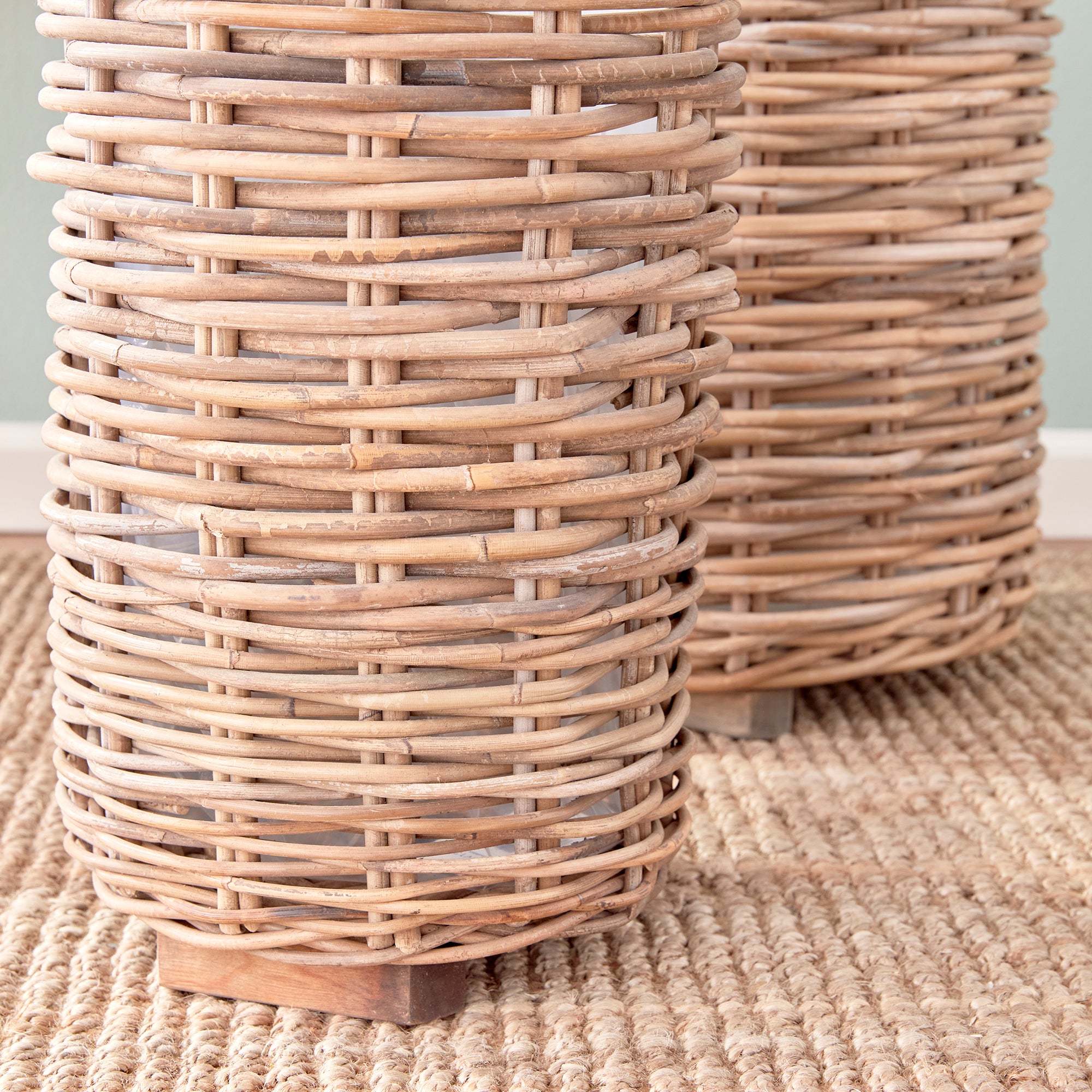 Made of a thick, woven rattan this set of two tall baskets are made to last. Furnished with a plastic liner to protect, and teak feet adding stability and elevating from the floor keeping them dry. Just as smart as they are beautiful. Amethyst Home provides interior design, new construction, custom furniture, and area rugs in the Boston metro area.