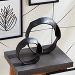 A matte black finish and rough, organic repeated circular shapes make these cast aluminum sculptures unique. A  contemporary touch for home office or den on book shelf, mantle or console. Amethyst Home provides interior design, new construction, custom furniture, and area rugs in the Miami metro area.