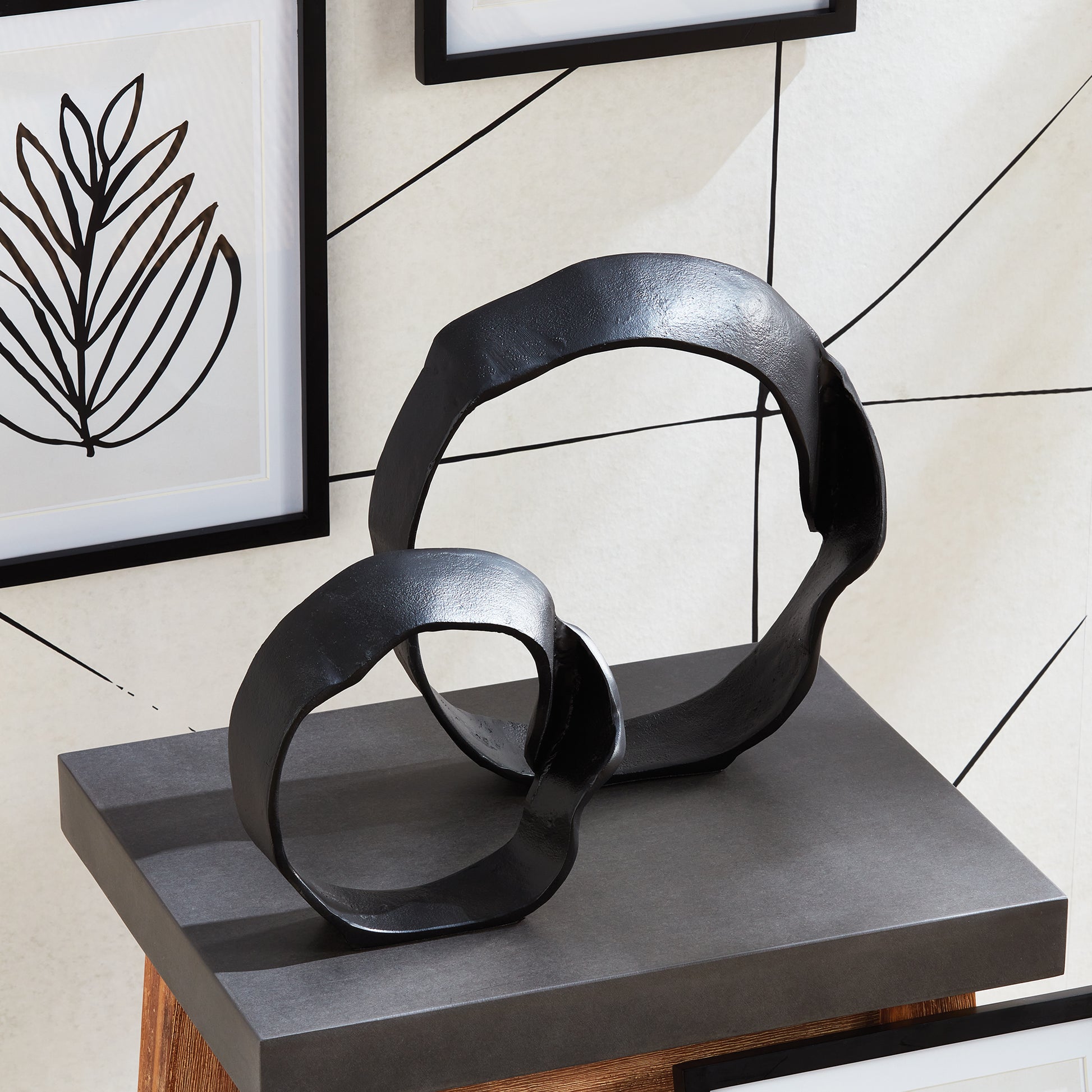 A matte black finish and rough, organic repeated circular shapes make these cast aluminum sculptures unique. A  contemporary touch for home office or den on book shelf, mantle or console. Amethyst Home provides interior design, new construction, custom furniture, and area rugs in the Miami metro area.