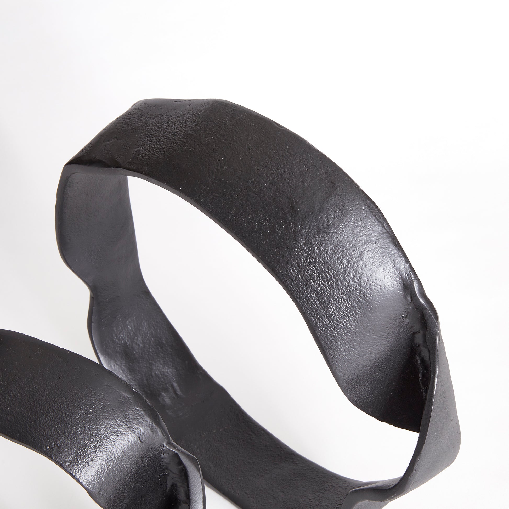 A matte black finish and rough, organic repeated circular shapes make these cast aluminum sculptures unique. A  contemporary touch for home office or den on book shelf, mantle or console. Amethyst Home provides interior design, new construction, custom furniture, and area rugs in the Portland metro area.