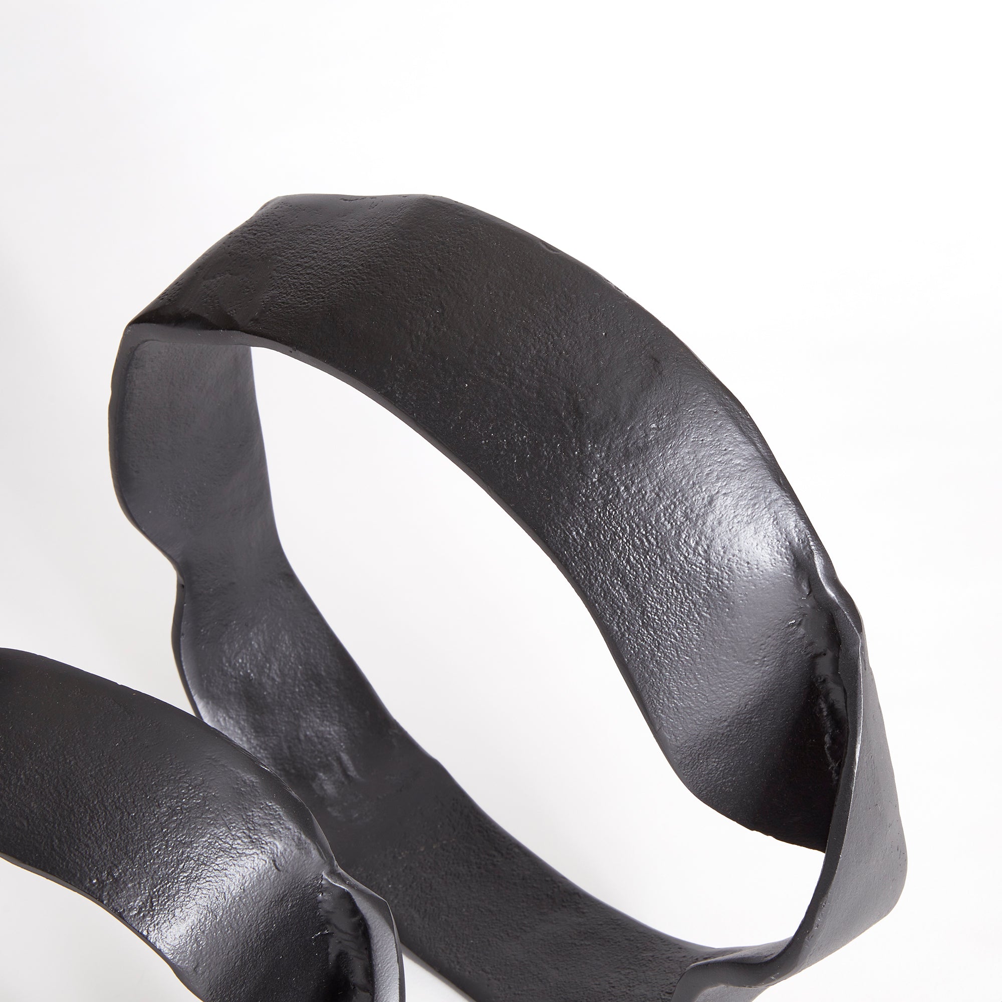 A matte black finish and rough, organic repeated circular shapes make these cast aluminum sculptures unique. A  contemporary touch for home office or den on book shelf, mantle or console. Amethyst Home provides interior design, new construction, custom furniture, and area rugs in the Portland metro area.