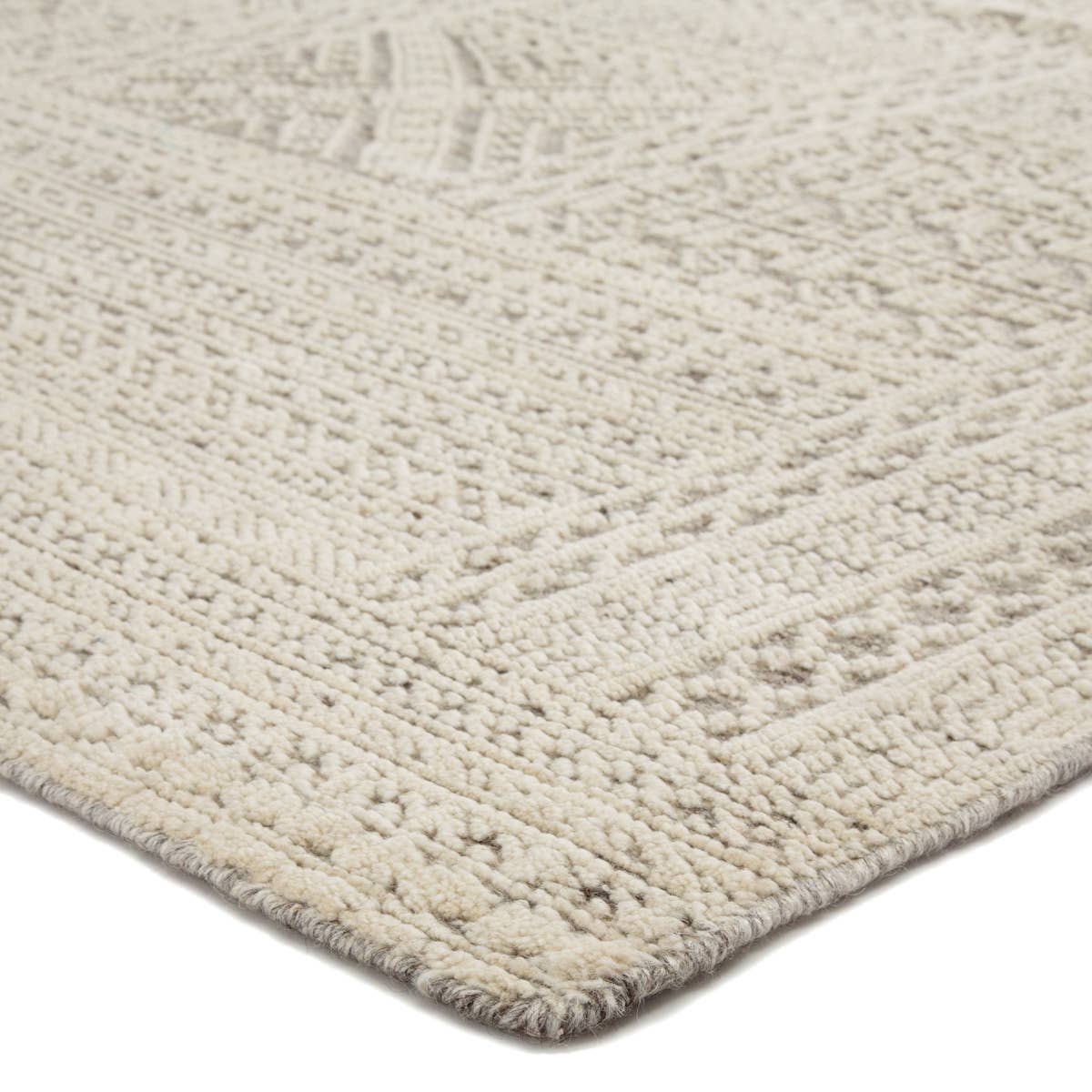 The captivating Reign collection introduces detail-rich design and inviting carved pile to contemporary and traditional homes alike. The hand-knotted Jadene rug boasts an intricate geometric design in a neutral ivory and light gray colorway. This wool rug's textured pattern grounds spaces with striking depth and dimension.  Hand-Knotted 100% Wool REI07