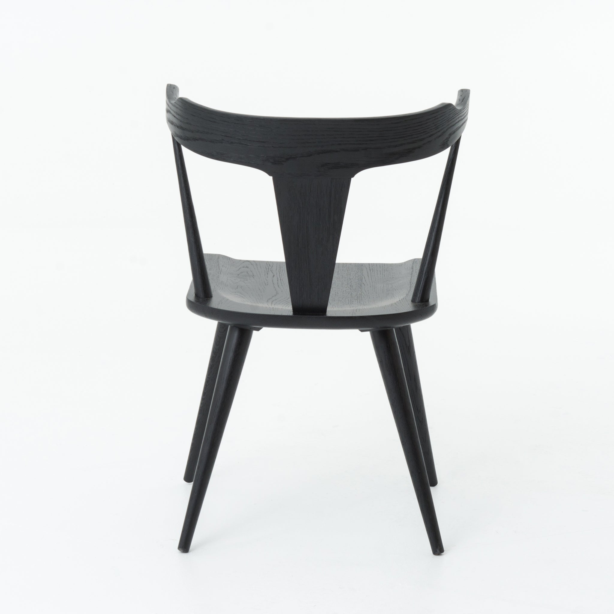 Featuring Ripley Black Dining Chair by Four Hands at Amethyst Home. This new take on the mid-century Windsor chair, the Ripley Dining Chair has a bowed, sculptural silhouette. A soft black finish adds movement to the wood by highlighting the natural grain of weathered oak. The chair is perfect for the chic, modern dining room look or that special nook in y.  Amethyst Home provides interior design, new home construction design consulting, vintage area rugs, and lighting in the Calabasas metro area.