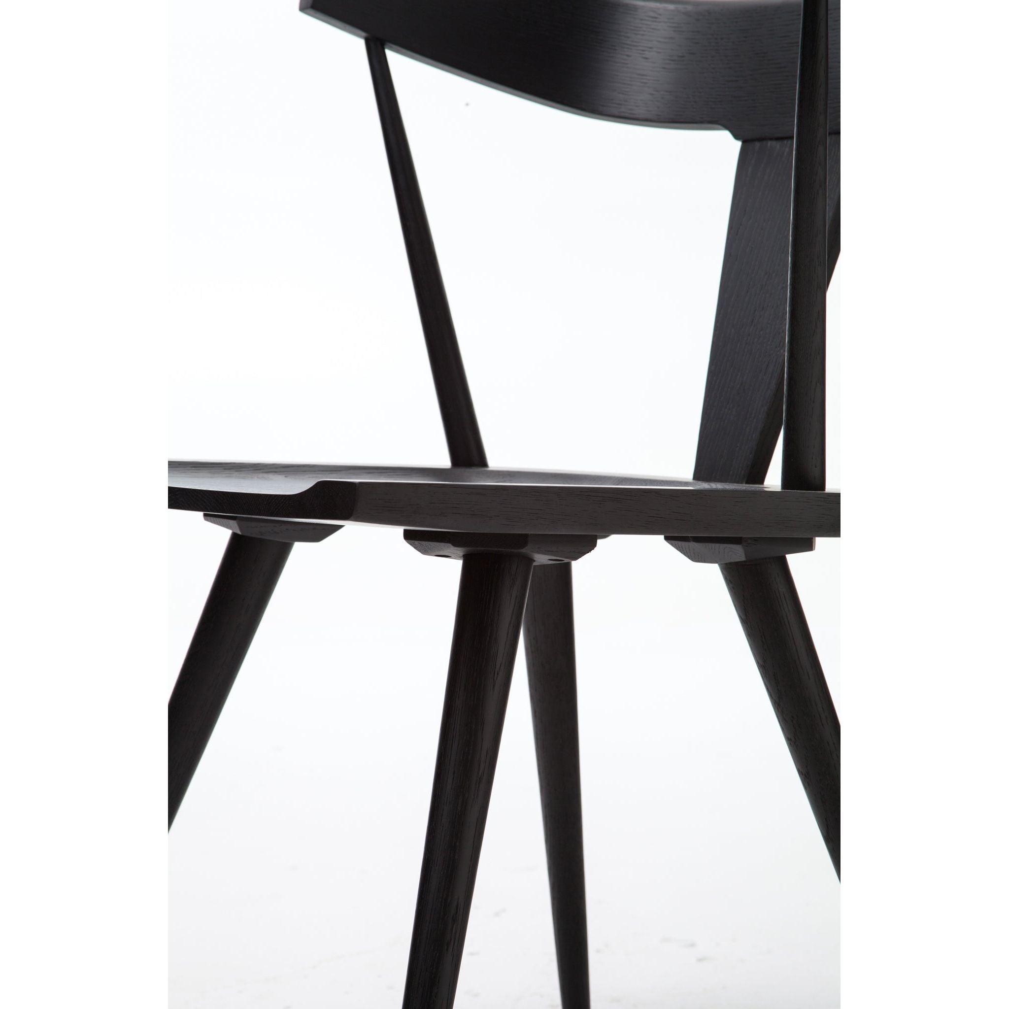 This new take on the mid-century Windsor chair, the Ripley Dining Chair has a bowed, sculptural silhouette. A soft black finish adds movement to the wood by highlighting the natural grain of weathered oak. The chair is perfect for the chic, modern dining room look.