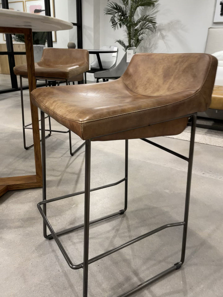 Upgrade your kitchen or dining room with this sleek, cocktail-ready Starlet Counter + Bar Stool - Open Road Brown Leather that showcases poise and comfort. This adds a cool sophistication to your space with its slim iron frame and luxe leather upholstery. 