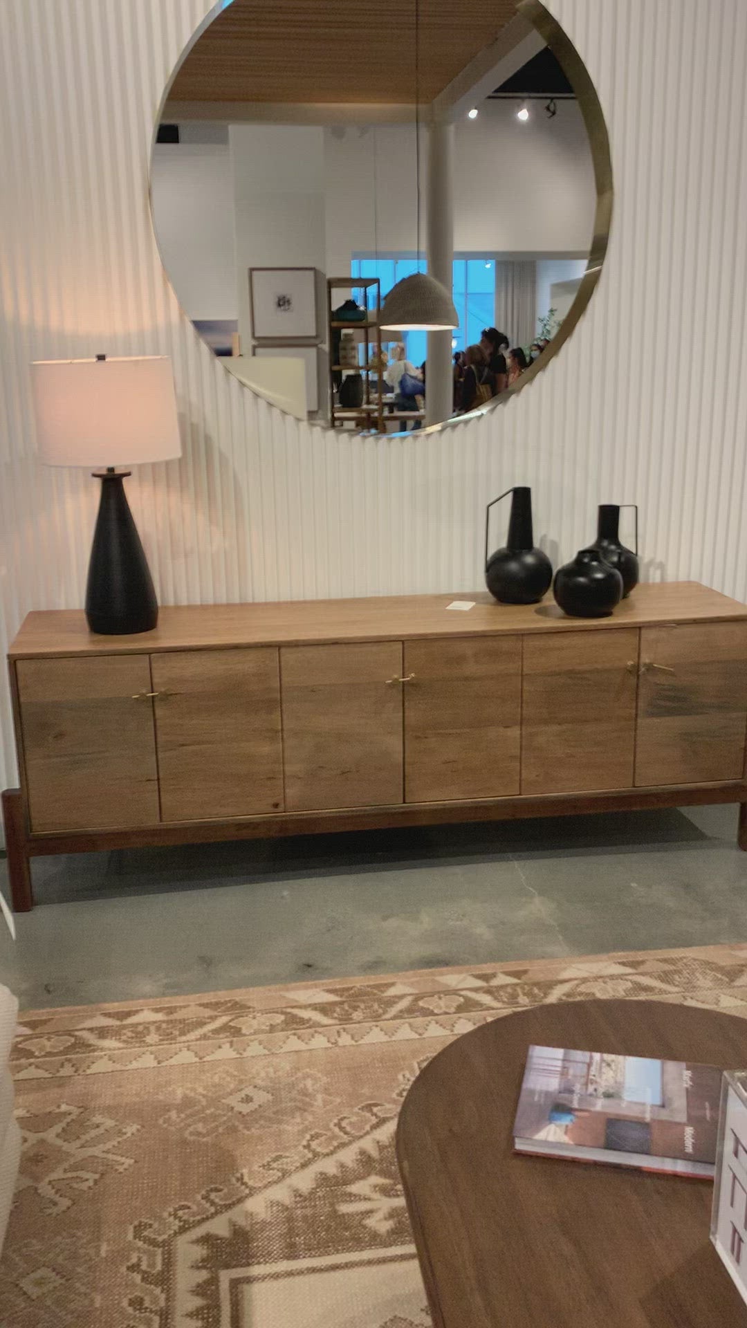 Load video: We love mid-century feel to this Reza Media Console - Smoked Honey. Finished in a light, smoked honey, a clean-lined parawood console sits in an arched cradle base of toasted acacia, for fresh contrast. Twist-lock metal hardware adds a clever finishing touch. Rear cutouts for media cord management. Amethyst Home provides interior design, new home construction design consulting, vintage area rugs, and lighting in the Los Angeles metro area.