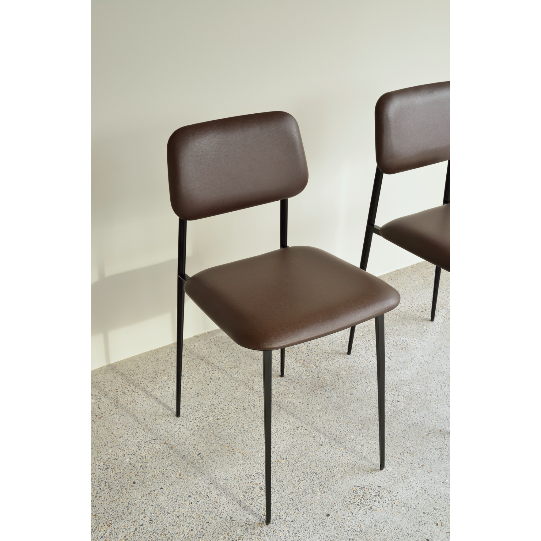 This DC Dining Chair is beautiful, minimalistic metal silhouette that would add an air of elegance to your dining table or kitchen. We love the details of the angled metal and the simplicity of this stunning chair.  Dimensions: 17"w x 19"d x 32.5"h  Weight: 19 lbs  Seat Height: 20"  Material: Metal Finish: Chocolate Leather Upholstery