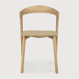 This Oak Bok Dining Chair features an airy shape with rock-solid construction,  making this piece a timeless and remarkable design to enjoy for years to come. Pair with a dining table or stand-alone against a wall, hallway, or end of the bed! Designed by Alain can Havre  Dimensions: 20"w x 21.5"d x 30"h  Weight: 20 lbs  Seat Height: 18"  Material: Oak, 100% solid wood Finish: Oiled