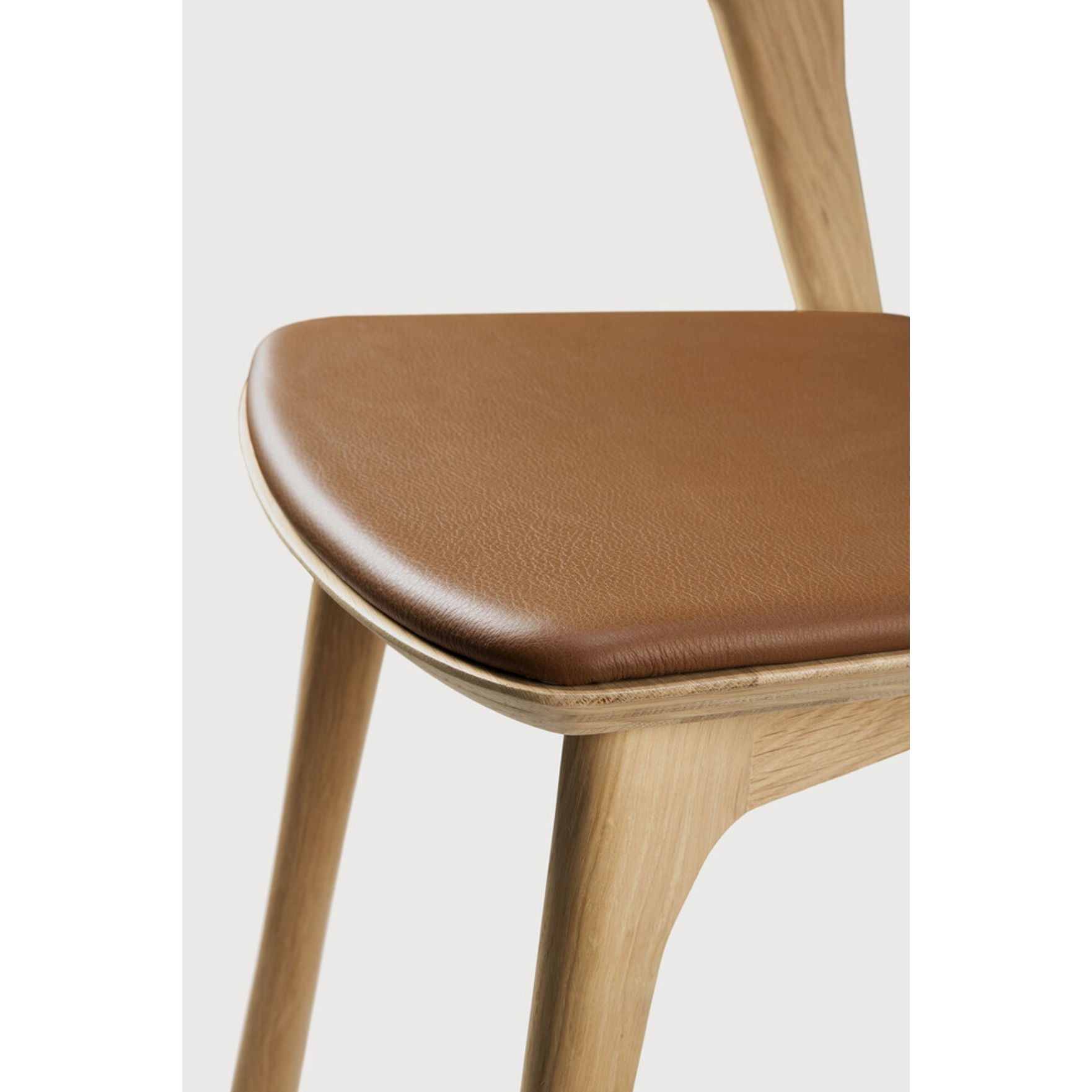This Oak Bok Dining Chair features an airy shape with rock-solid construction,  making this piece a timeless and remarkable design to enjoy for years to come. Pair with a dining table or stand-alone against a wall, hallway, or end of the bed! Designed by Alain can Havre  Dimensions: 20"w x 21.5"d x 30"h  Weight: 15 lbs  Seat Height: 19"  Material: Oak, 100% solid wood Finish: Varnished