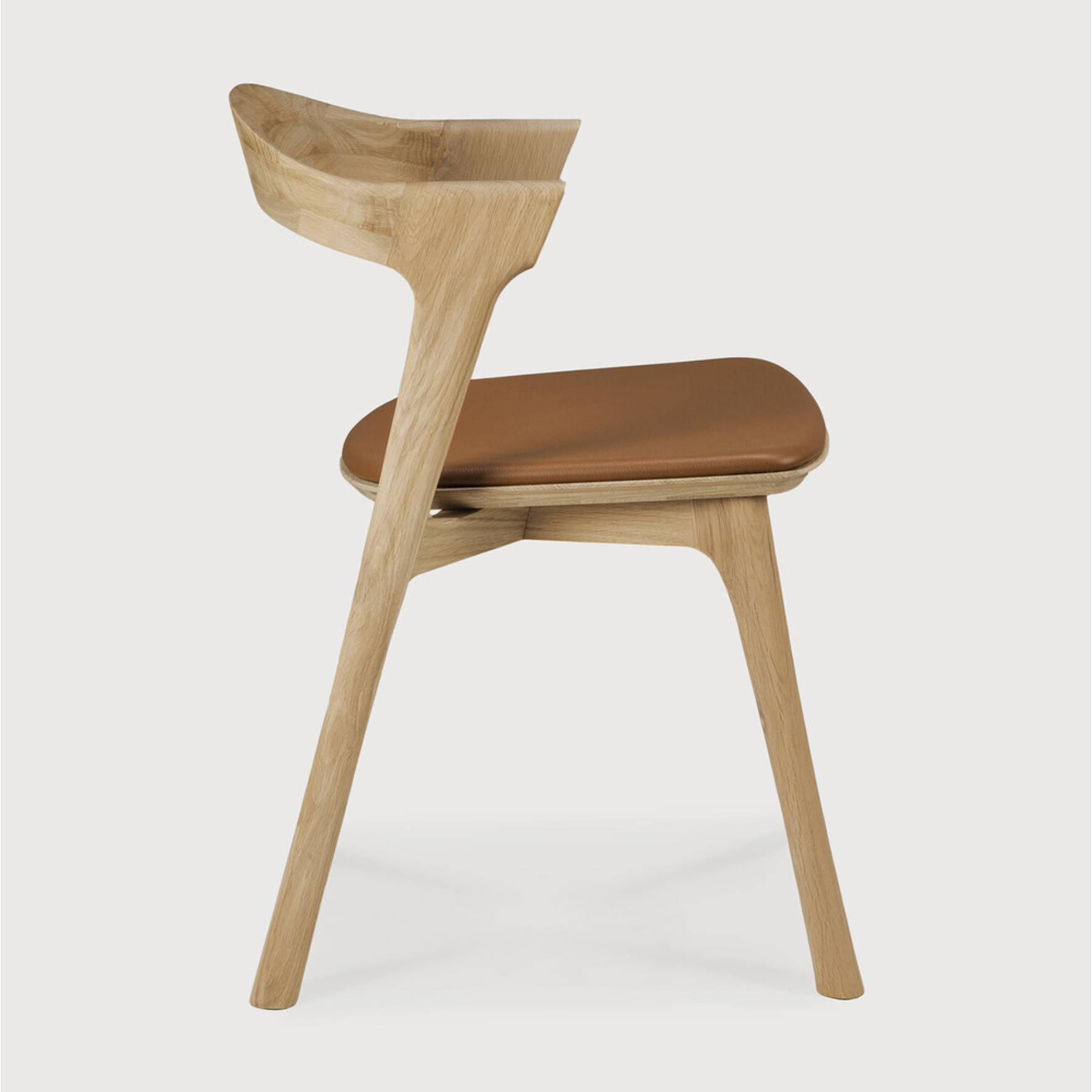This Oak Bok Dining Chair features an airy shape with rock-solid construction,  making this piece a timeless and remarkable design to enjoy for years to come. Pair with a dining table or stand-alone against a wall, hallway, or end of the bed! Designed by Alain can Havre  Dimensions: 20"w x 21.5"d x 30"h  Weight: 15 lbs  Seat Height: 19"  Material: Oak, 100% solid wood Finish: Varnished