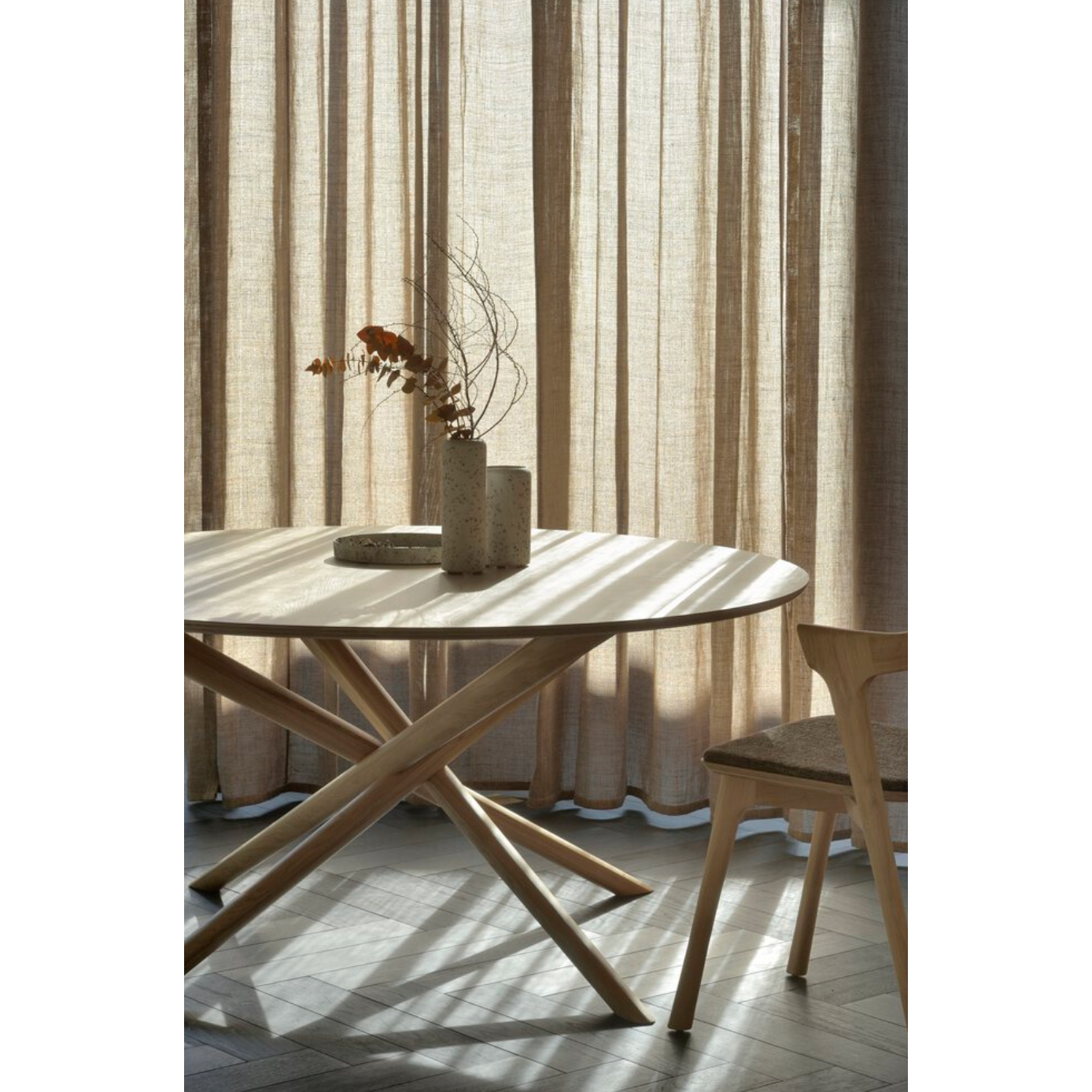 We love the sculptural character of this Oak Mikado Dining Table - Round. The legs interlock like a well-thought-out puzzle, making it easier to interact with your guests and allows you to converse with your family and friends for years to come!  Designed by Alain van Havre  Material: Oak, 100% Solid Wood Finish: Oiled