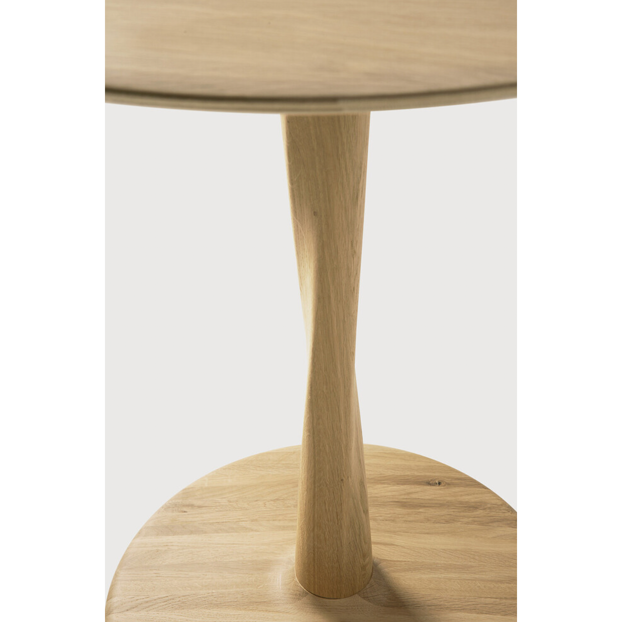 Airy with subtle complexities, this Oak Round Torsion Dining Table incorporates advanced woodworking techniques to create a light table top with a torsaded base of sculptural elegance -- sure to elevate the look for any dining or kitchen area.   Material: Oak, 100% Solid Wood Finish: Varnished
