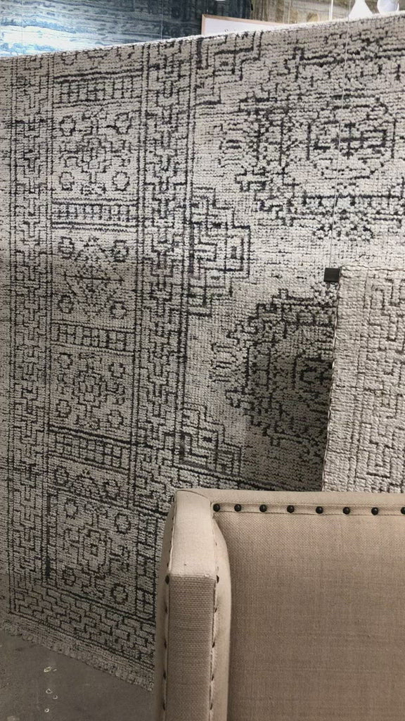 Hand-knotted in India of viscose and cotton, the Vestige White / Black Area Rug recalls ancient khotan rugs in an updated color palette. Soft underfoot, the silken yarns temper the graphic motifs to create a versatile foundation.  Hand Knotted 89% Viscose | 11% Cotton VQ-01 White / Black