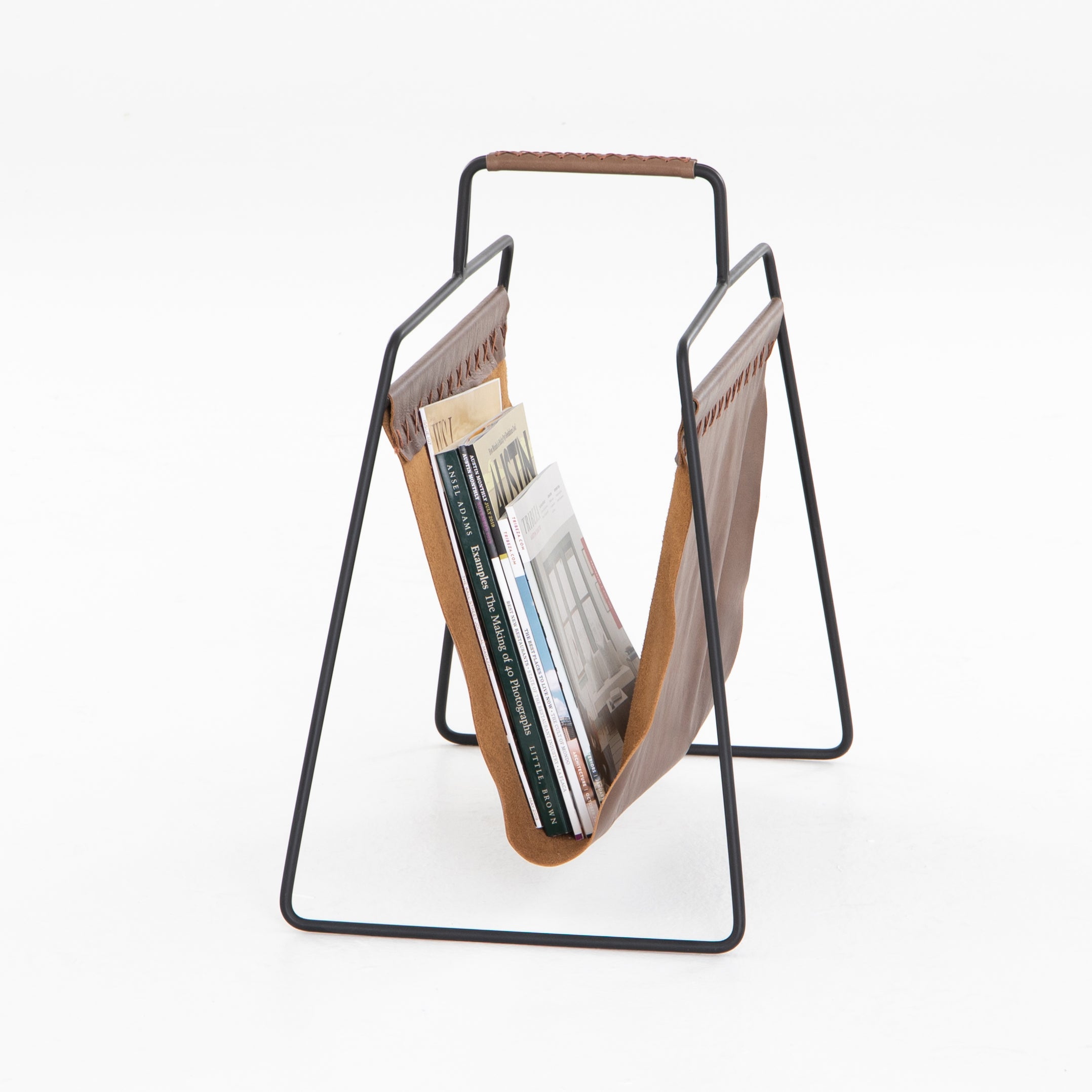 We love the cross-stitching details on this patina brown, top grain leather Aesop Magazing Rack. A gorgeous piece to place all your favorite magazines or important papers in, while also bringing a stylish mid-century vibe to your office or other space.  Overall Dimensions: 18.50"w x 11.75"d x 19.00"h Materials: Top Grain Leather, Iron Colors: Patina Brown, Smooth Jet Black