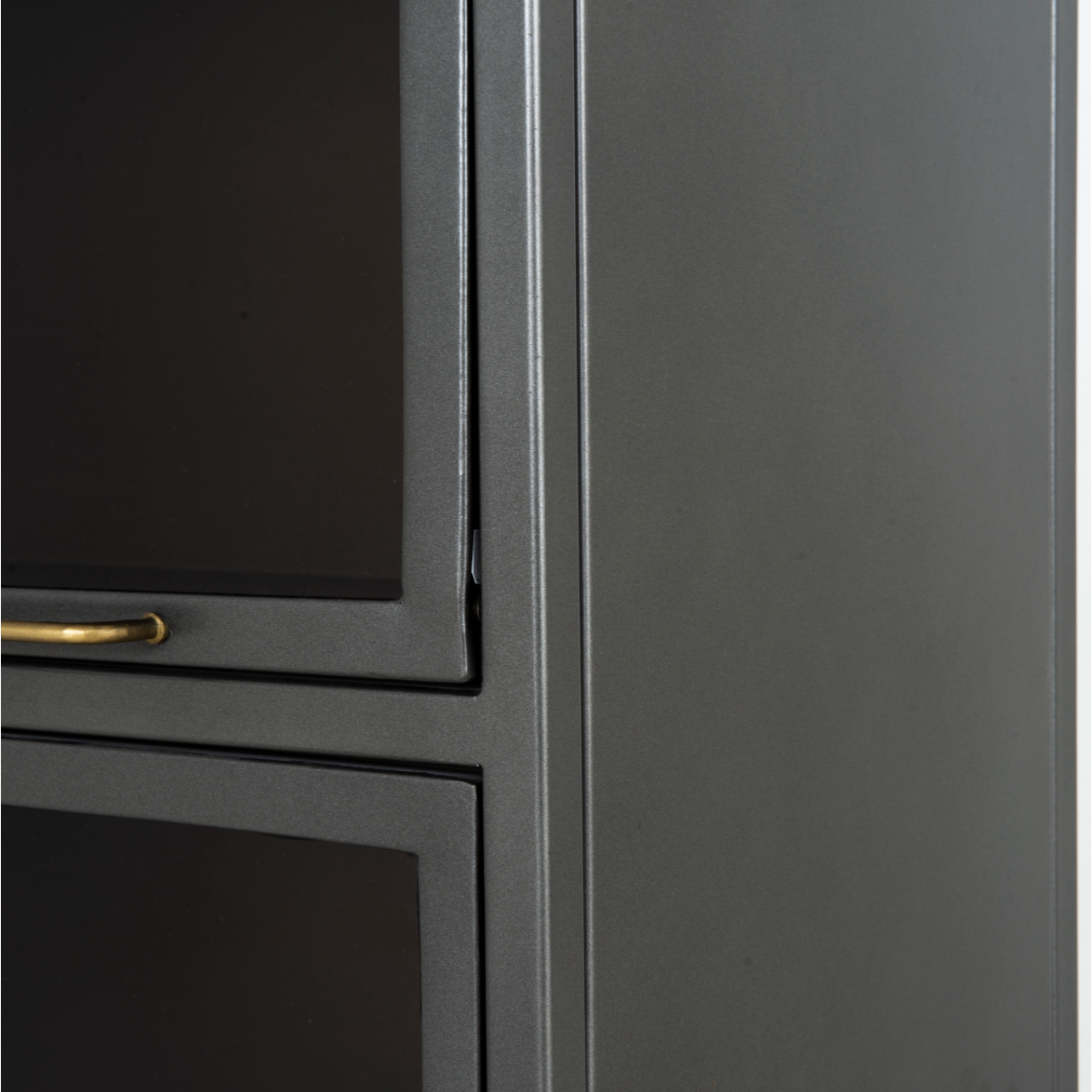 Inspired by the stackable barrister-style shelving, iron casing is finished in a gunmetal for a fresh industrial look, with smoked glass panes with flat brass hardware cover door fronts, each lifting to spacious compartments for storage of books and treasures.  Overall Dimensions: 32.00"w x 15.00"d x 82.00"h  Colors: Smoked Glass, Flat Brass, Gunmetal Materials: Glass, Iron
