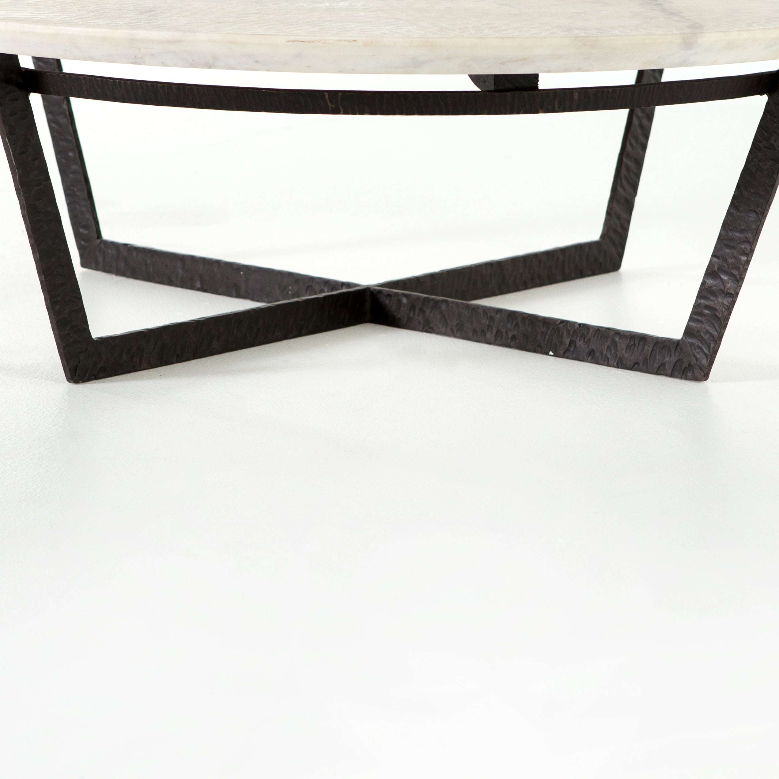 We love the textured top and geometric base of this Felix Round Coffee Table - Sandblasted White Marble. Place in your living room or lounge area to bring a sophisticated look to the space.  Overall Dimensions: 48.00"w x 48.00"d x 15.00"h Colors: Rustic Fossil, Sandblasted White Marble Materials: Iron, Marble Weight: 189.6 lb