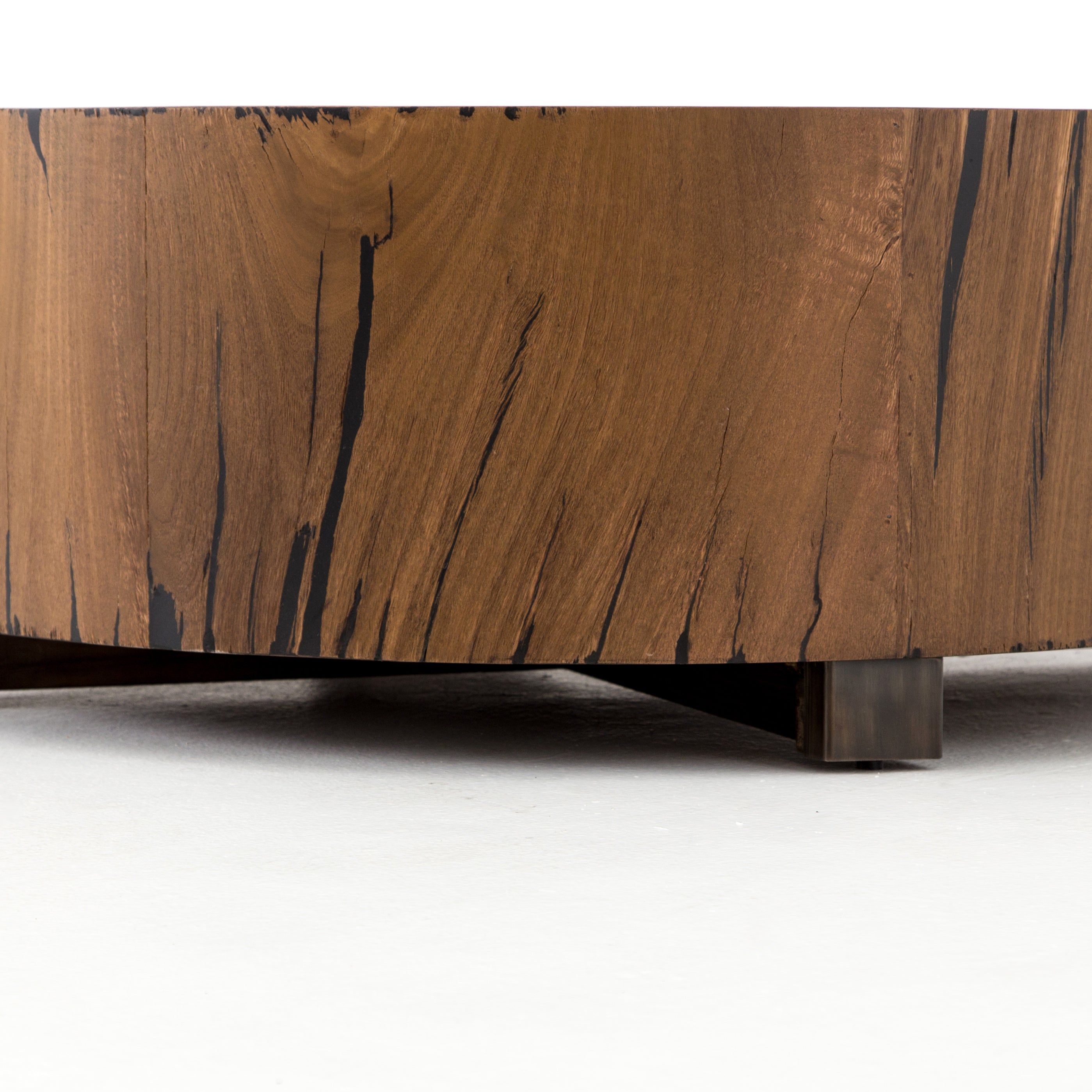 We love how the stunning forces of nature are captured in the Hudson Natural Yukas Coffee Table. Natural yukas wood is hand-shaped into a cylindrical silhouette and placed over a bronzed iron base to complete your living room space.   Overall Dimensions: 40"w x 40"d x 15"h  Colors: Natural Yukas Resin, Gunmetal Materials: Thick Yukas Veneer, Iron