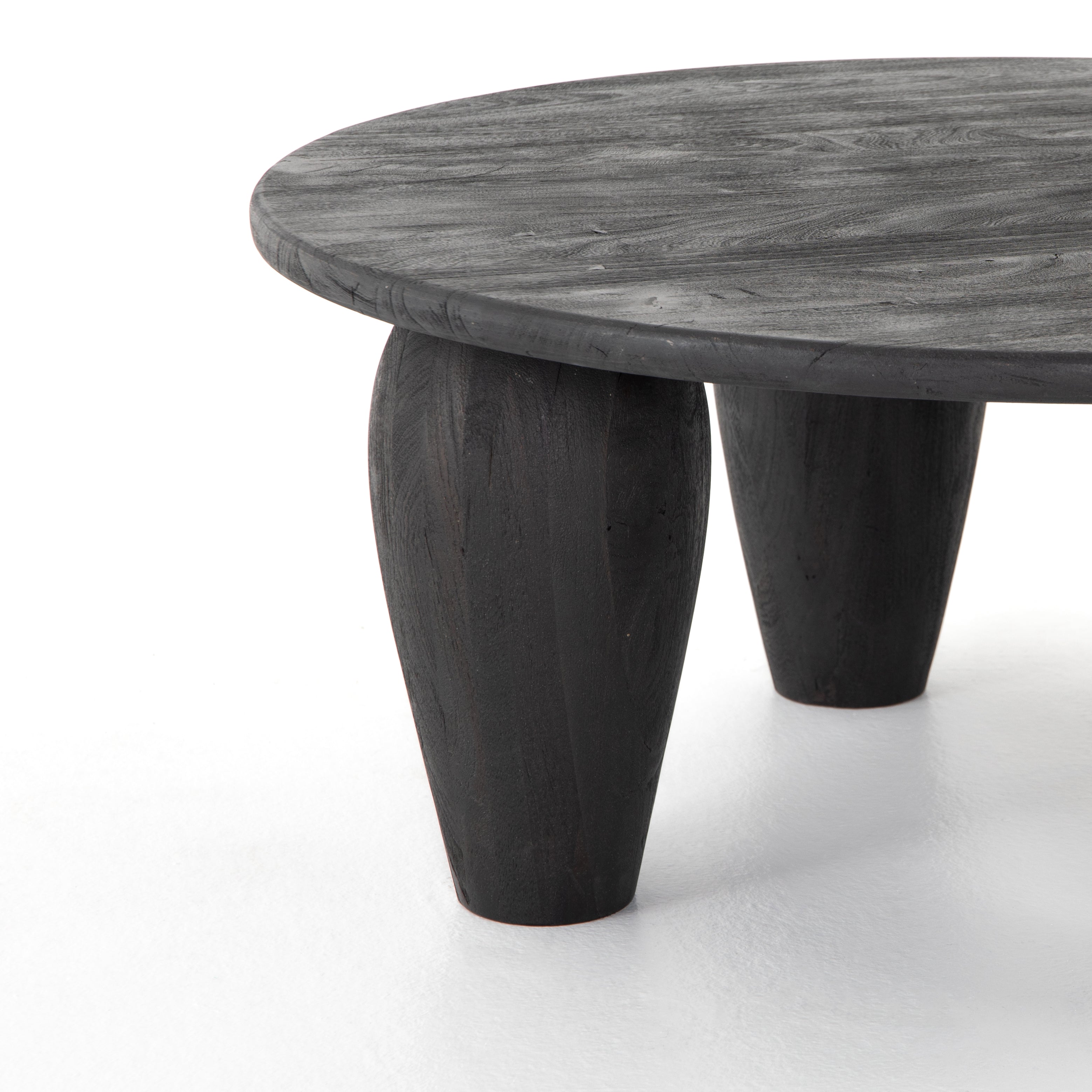 We love the shapely, substantial legs that support a slim, rounded tabletop of light black-finished reclaimed woods in this Maricopa Coffee Table - Dark Totem. A global, organic look with a handcrafted vibe.