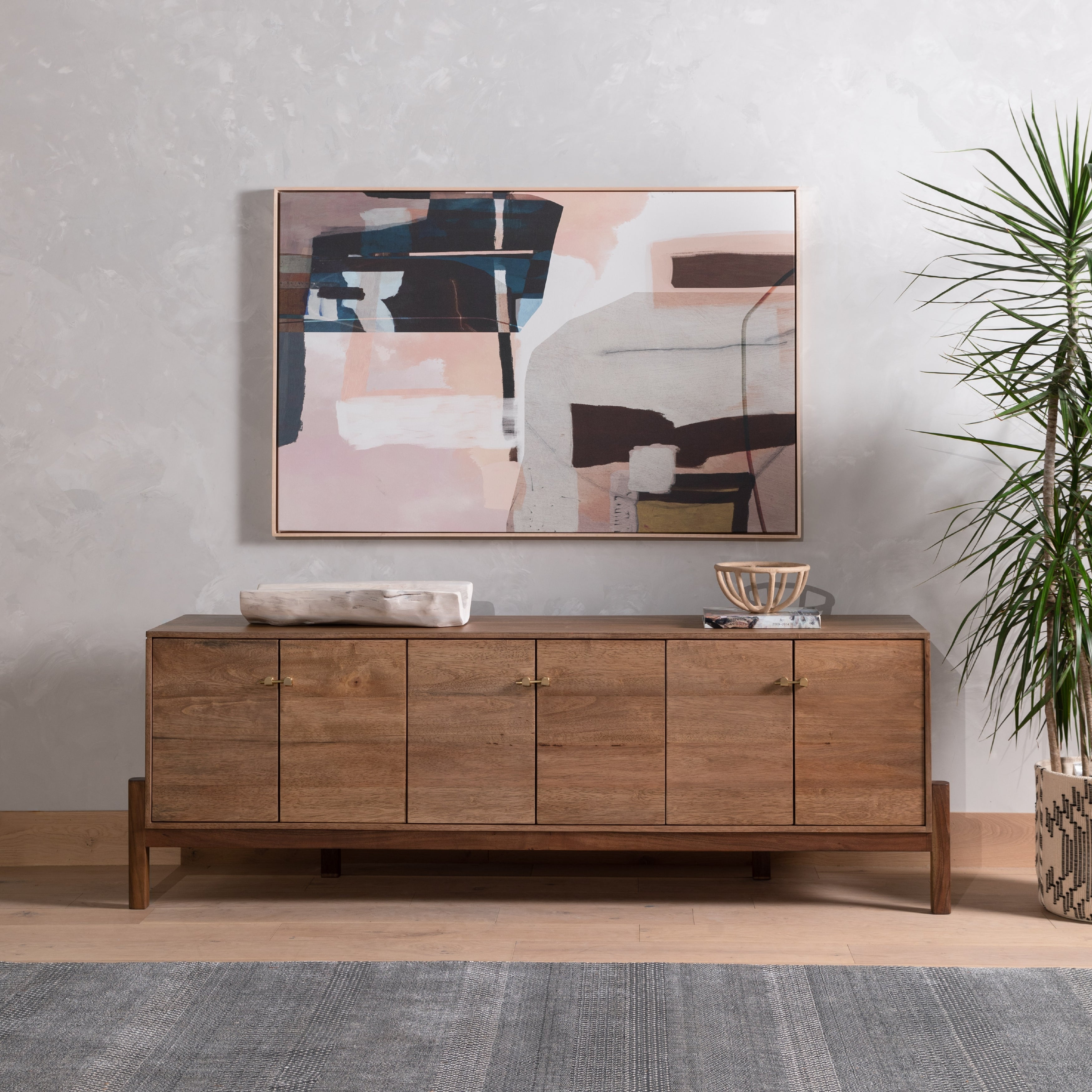 We love mid-century feel to this Reza Media Console - Smoked Honey. Finished in a light, smoked honey, a clean-lined parawood console sits in an arched cradle base of toasted acacia, for fresh contrast. Twist-lock metal hardware adds a clever finishing touch. Rear cutouts for media cord management.  Overall Dimensions: 84.00"w x 18.00"d x 28.25"h