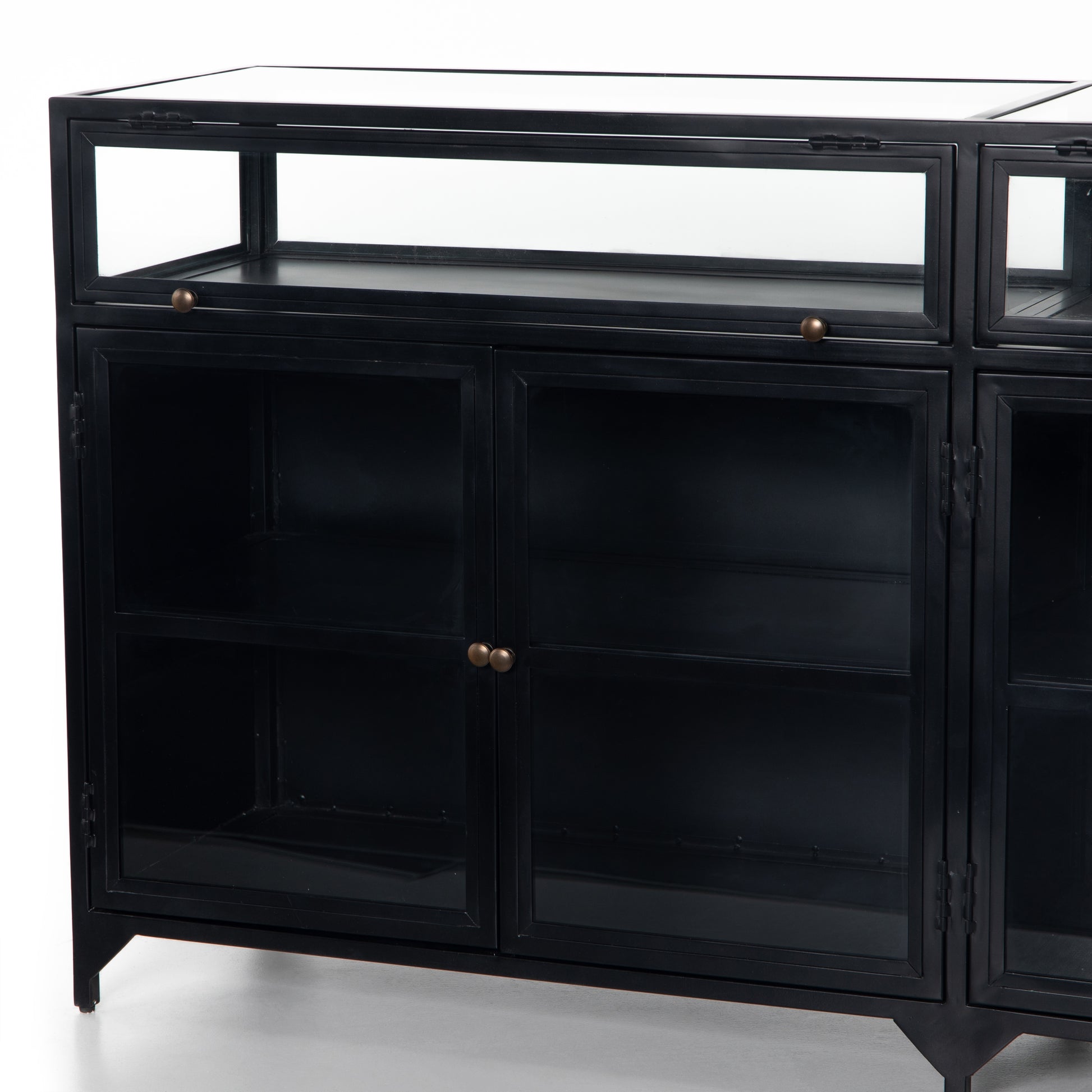 This Shadow Box Sideboard gives your inner collector a place to play. Store prized possessions behind clear glass fronts, with black-finished metal casing and brass hardware for contrast.  Overall Dimensions: 70.00"w x 17.25"d x 35.00"h