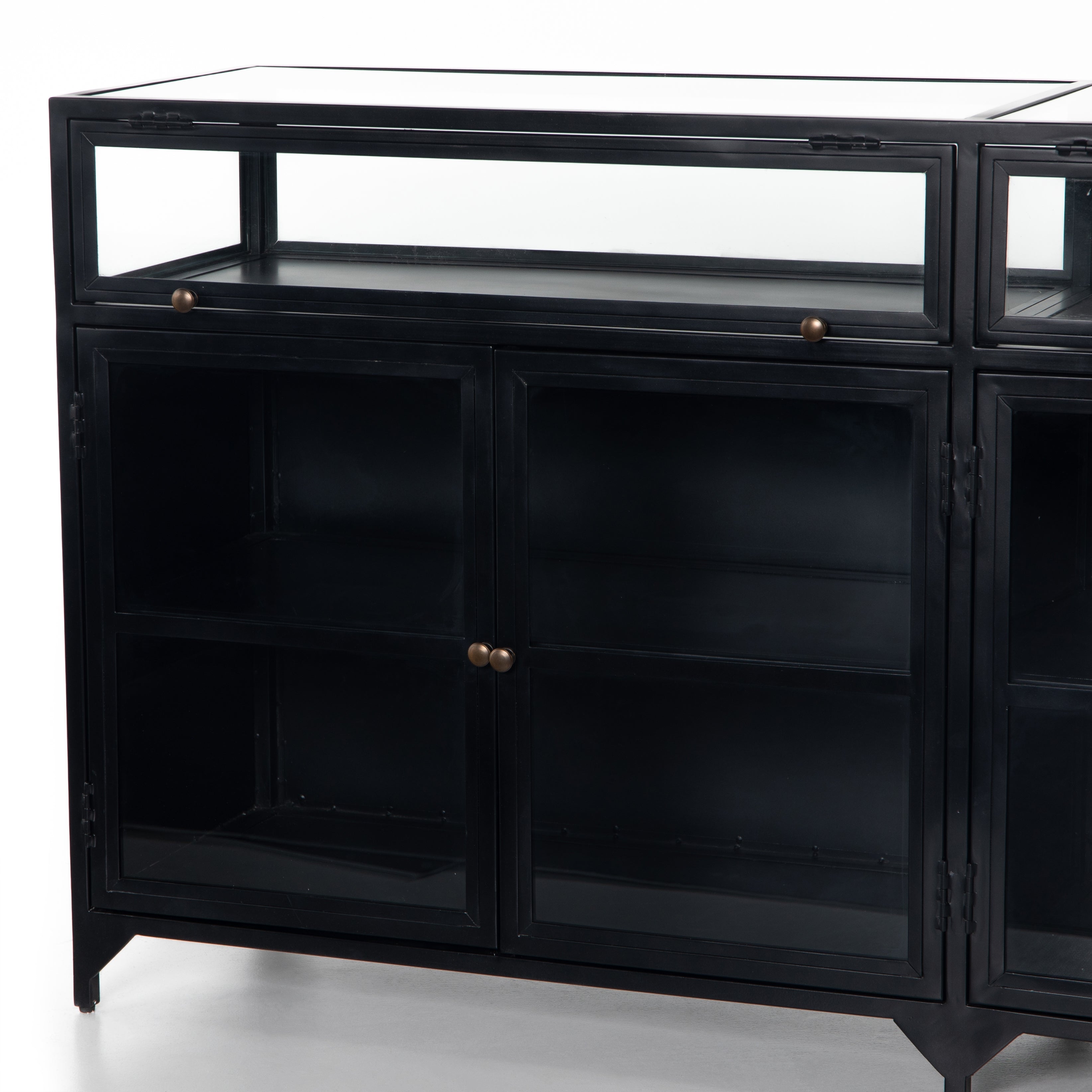 This Shadow Box Sideboard gives your inner collector a place to play. Store prized possessions behind clear glass fronts, with black-finished metal casing and brass hardware for contrast.  Overall Dimensions: 70.00"w x 17.25"d x 35.00"h