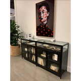 Featuring Shadow Box Sideboard - Black by Four Hands at Amethyst Home. This Shadow Box Sideboard gives your inner collector a place to play. Store prized possessions behind clear glass fronts, with black-finished metal casing and brass hardware for contrast.
Overall Dimensions: 70"W x 17.25"L x 35"H
Colors: Black, Weathered Bronze, Clear Glass, Tempered .  Amethyst Home provides interior design, new home construction design consulting, vintage area rugs, and lighting in the Kansas City metro area.