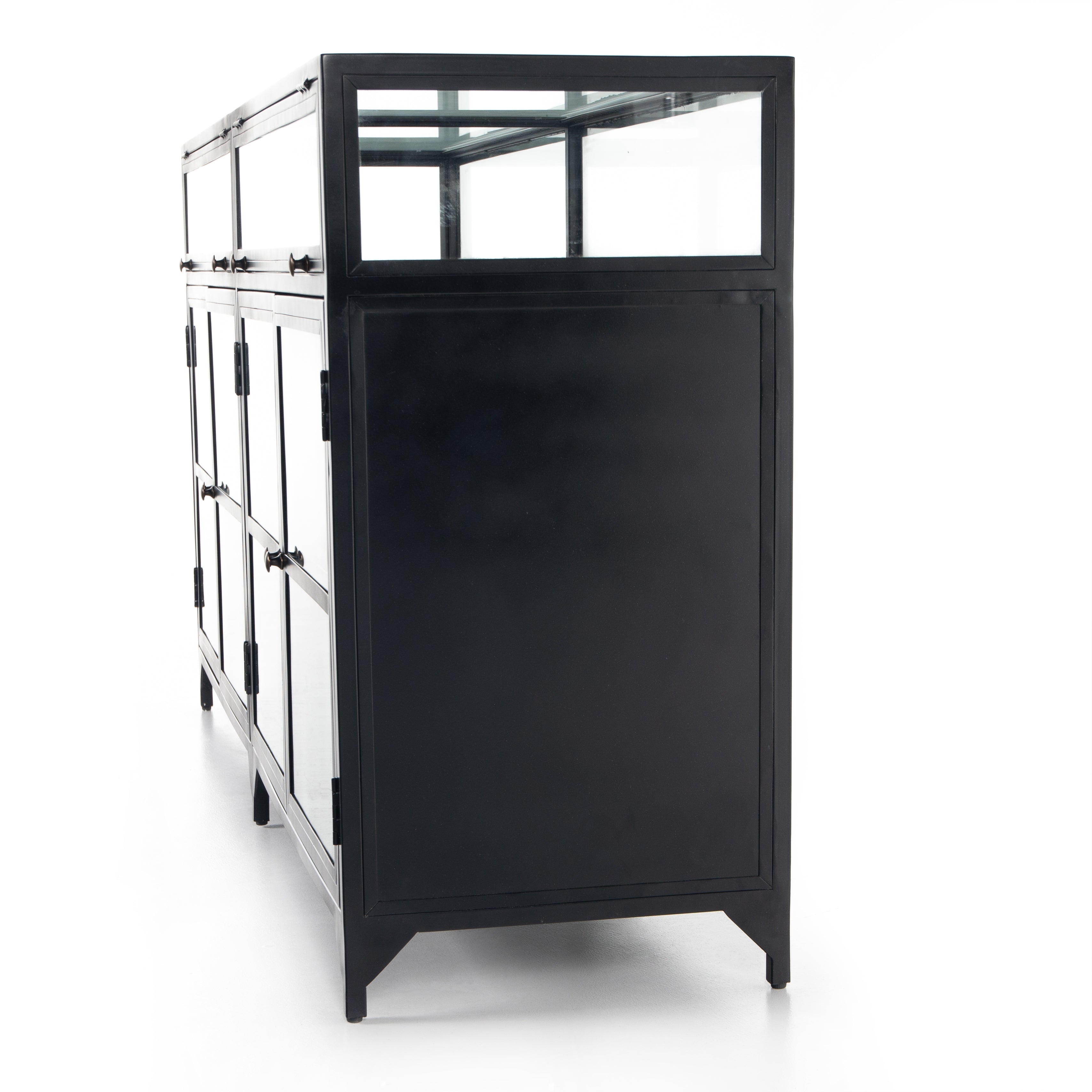 Featuring Shadow Box Sideboard - Black by Four Hands at Amethyst Home. This Shadow Box Sideboard gives your inner collector a place to play. Store prized possessions behind clear glass fronts, with black-finished metal casing and brass hardware for contrast.
Overall Dimensions: 70"W x 17.25"L x 35"H
Colors: Black, Weathered Bronze, Clear Glass, Tempered .  Amethyst Home provides interior design, new home construction design consulting, vintage area rugs, and lighting in the Los Angeles metro area.