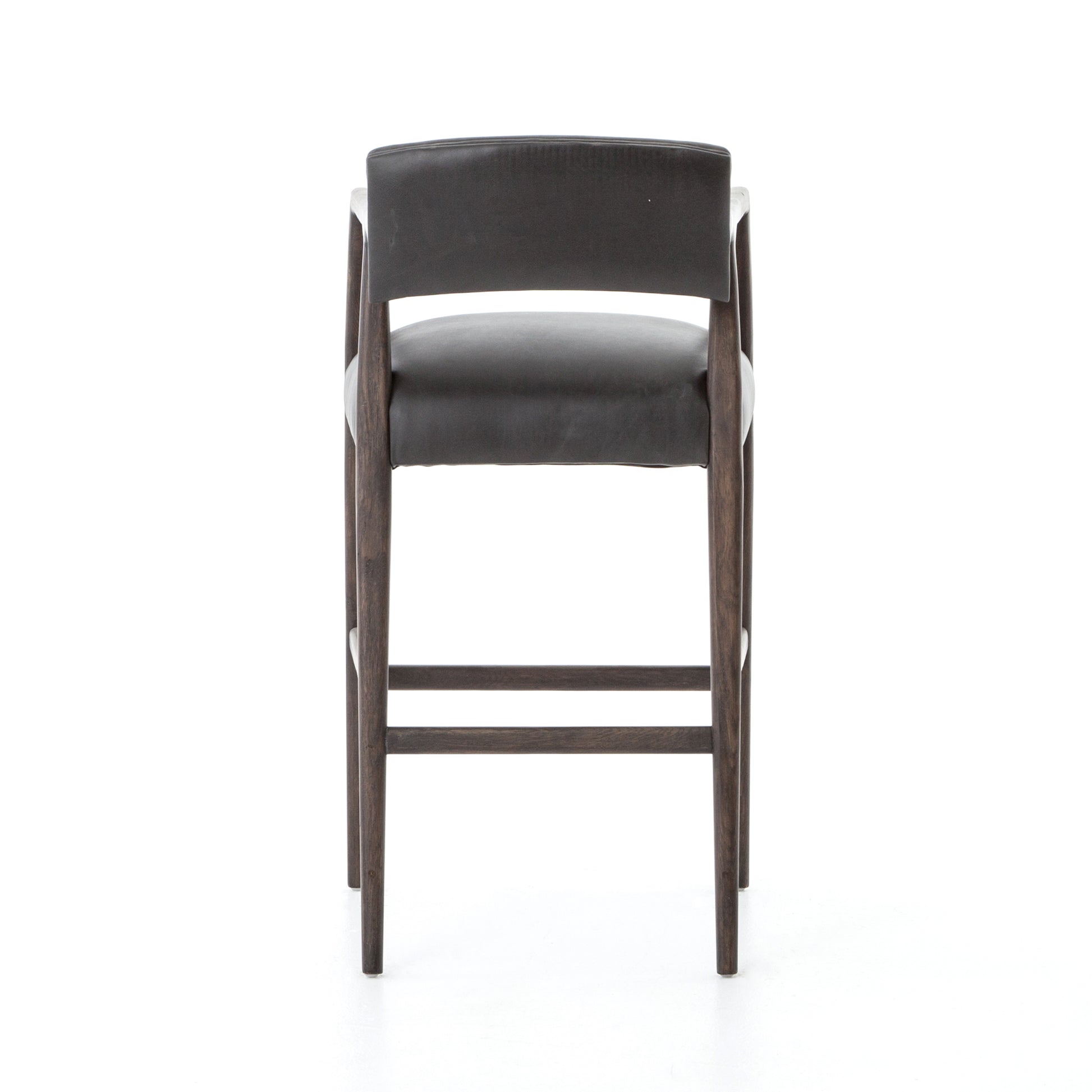 The Tyler Bar + Counter Stool - Ebony makes counter seating stylish with an angular, dark and smoky birch frame, a deep seat, and a striking, low-slung back. The stool is comfortable for long dinners and conversations with a covered black, top-grain leather seat and back.